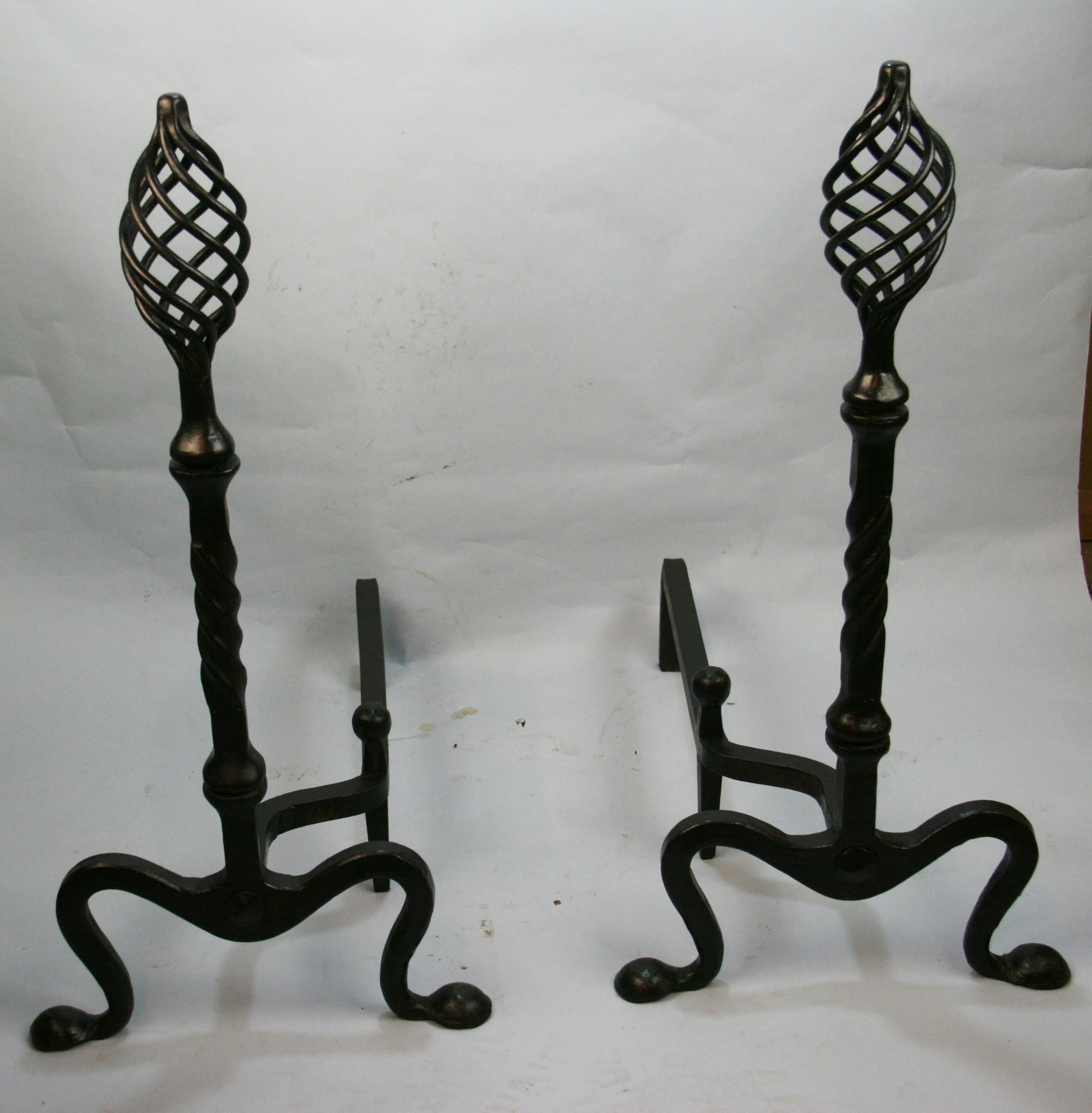 Pair hand forged andirons  mid 19th century.
Bird cage finials  spiral plinths and terminating on hand hammered  penny feet .