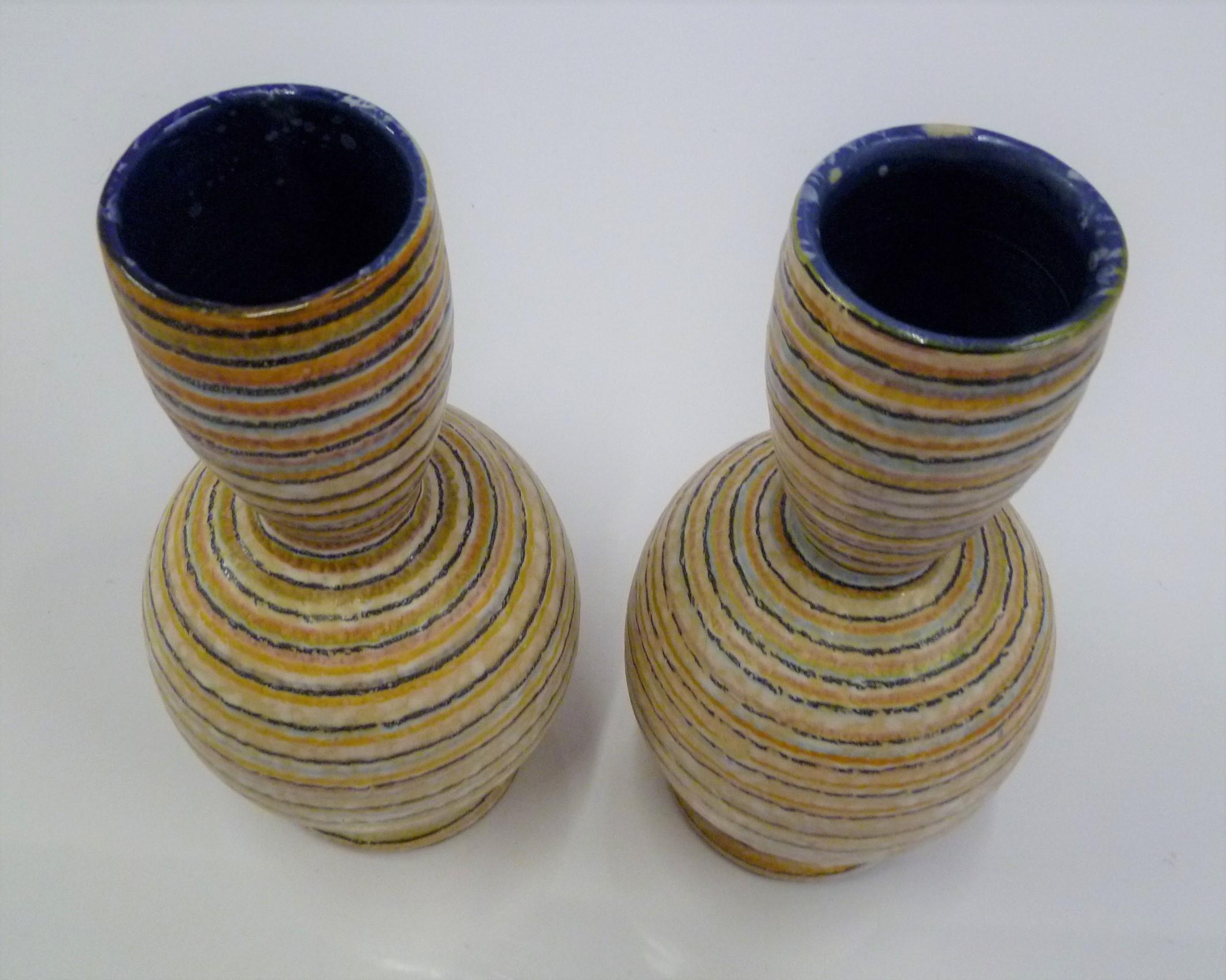 Pair of midcentury Italian Modern pottery vases handmade in Italy for the retailer Guildcraft from the 1960s. The shape and colorful bands covering their bodies, will brighten any room's decor. Fun and happy, the stripes are painted in tan, black,