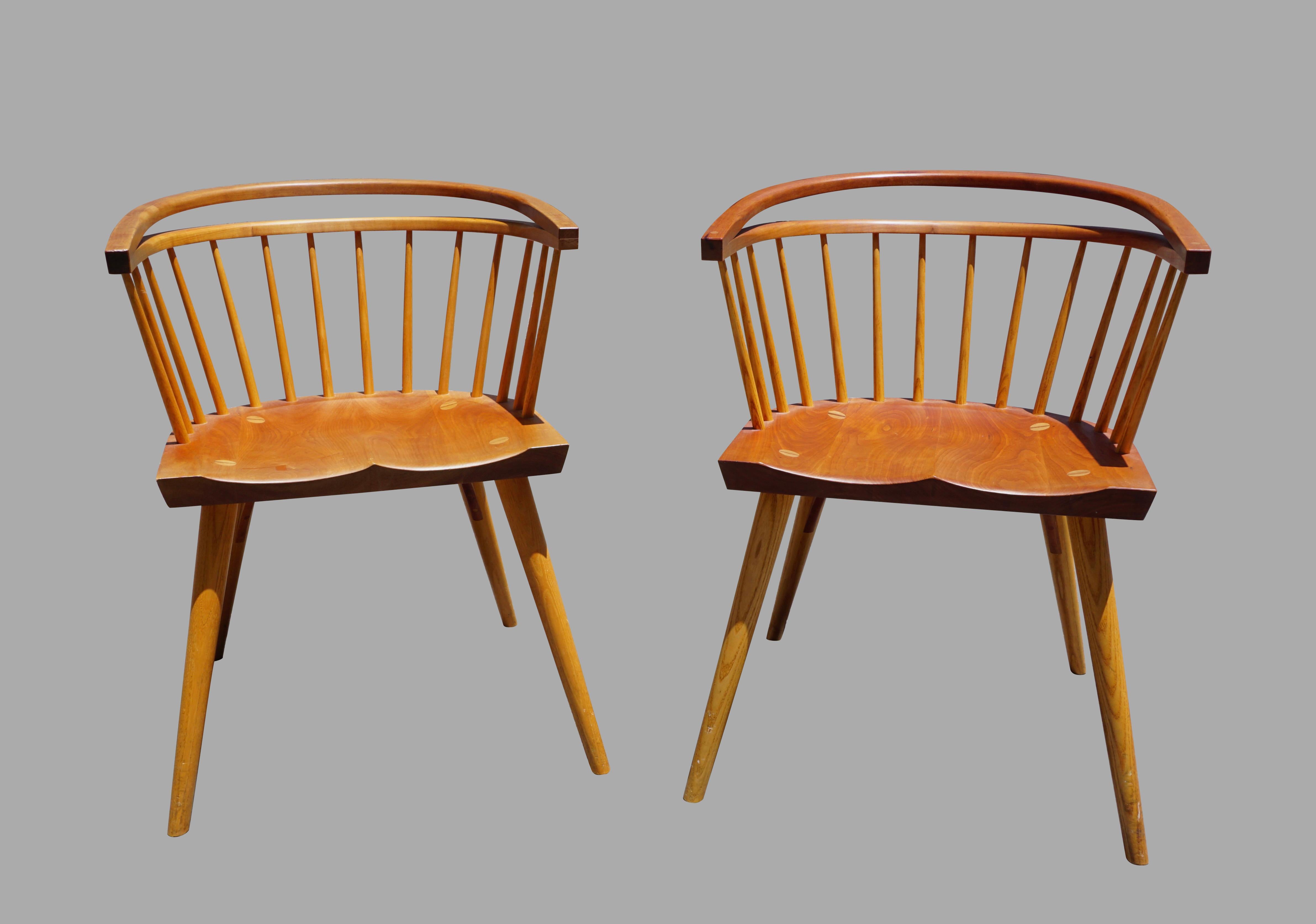A fine pair of handmade cherry armchairs by the renowned Maine firm of Thomas Moser, each stickback chair with a curved continuous arm, the back with a flexible crestrail, inscribed on the underside of the seats by their makers, as follows: Thomas
