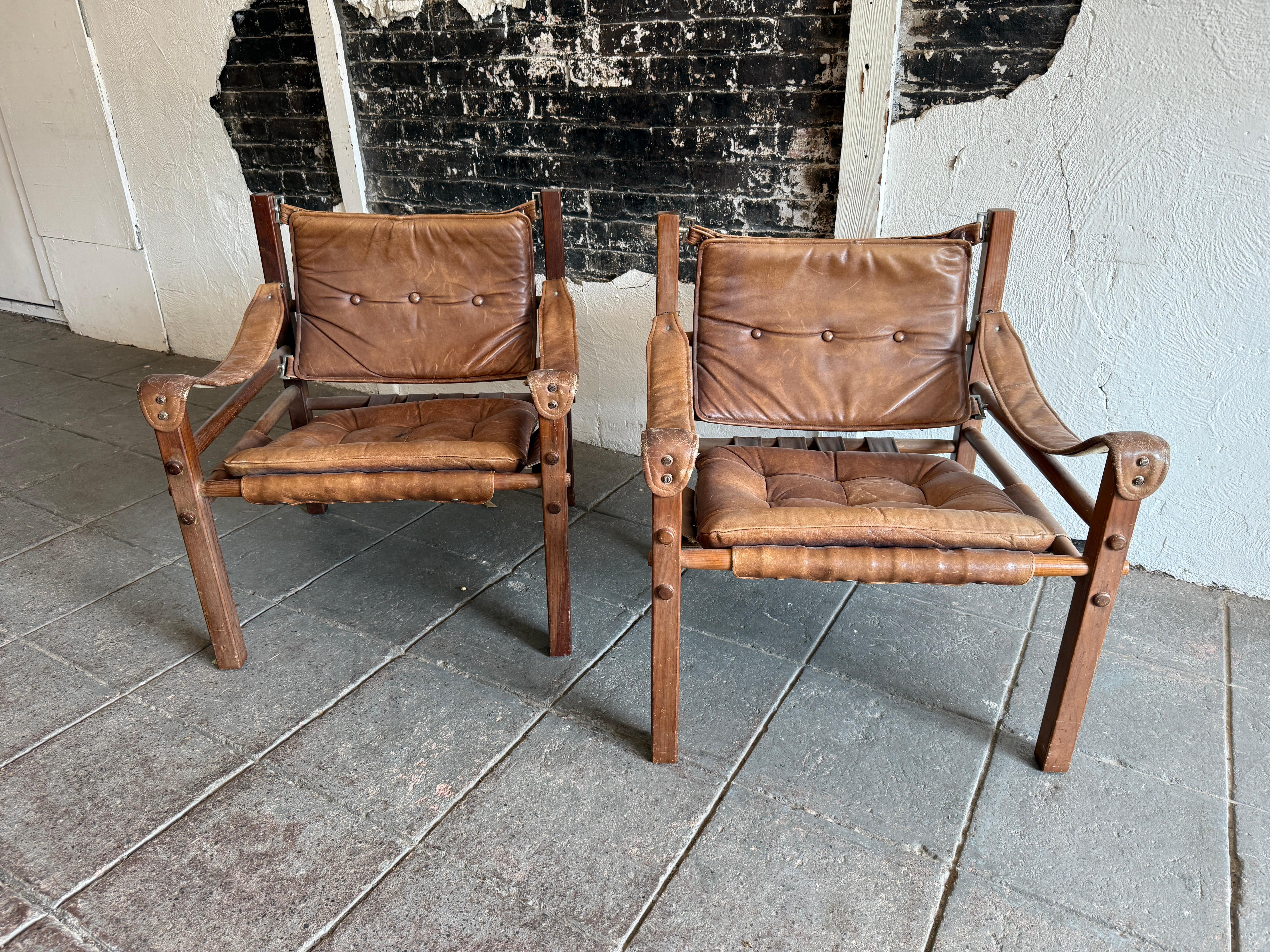 Pareja de sillones safari de cuero marrón de mediados de siglo con pátina Escandinavo moderno en venta