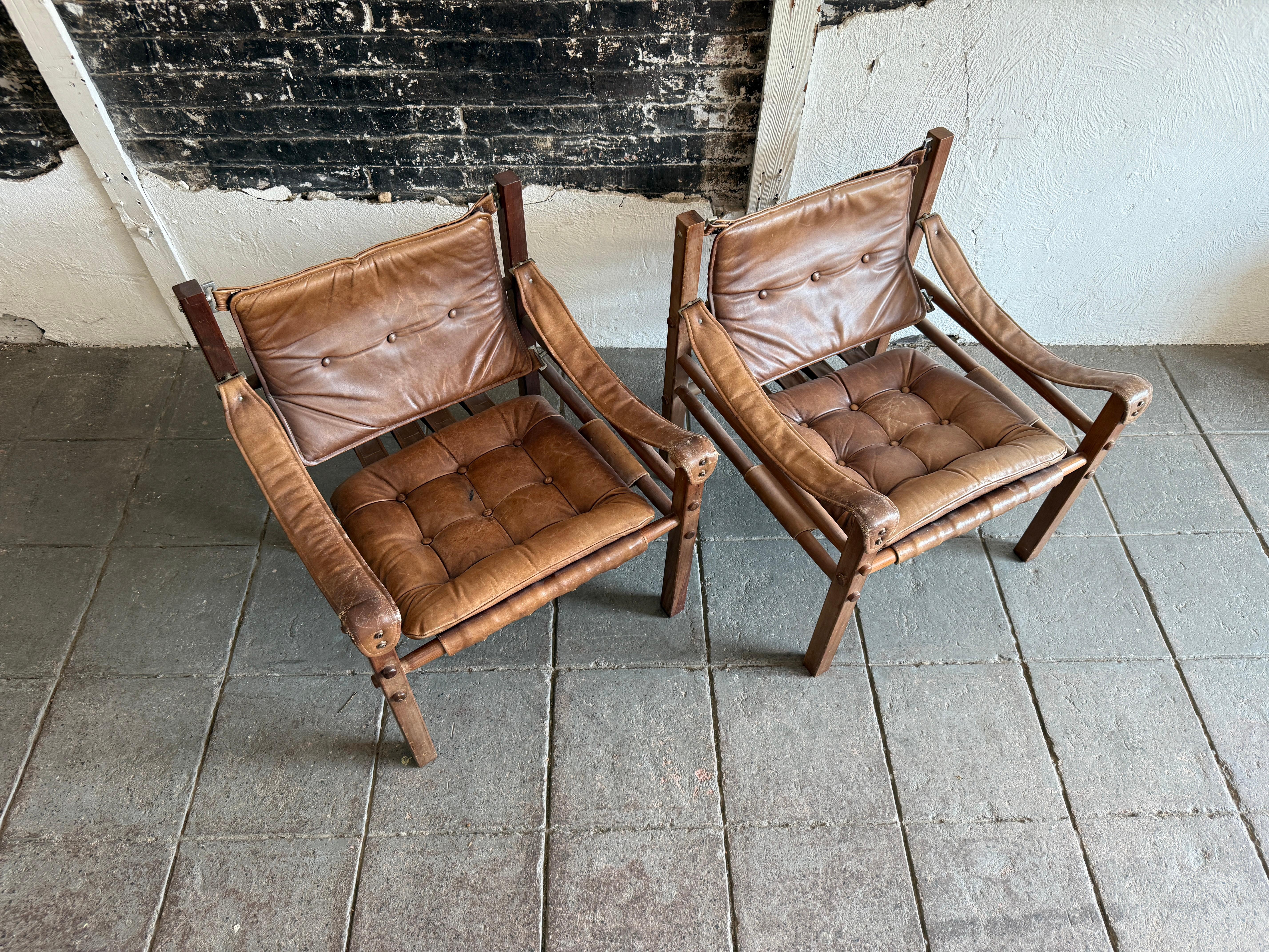 Pareja de sillones safari de cuero marrón de mediados de siglo con pátina Colombiano en venta