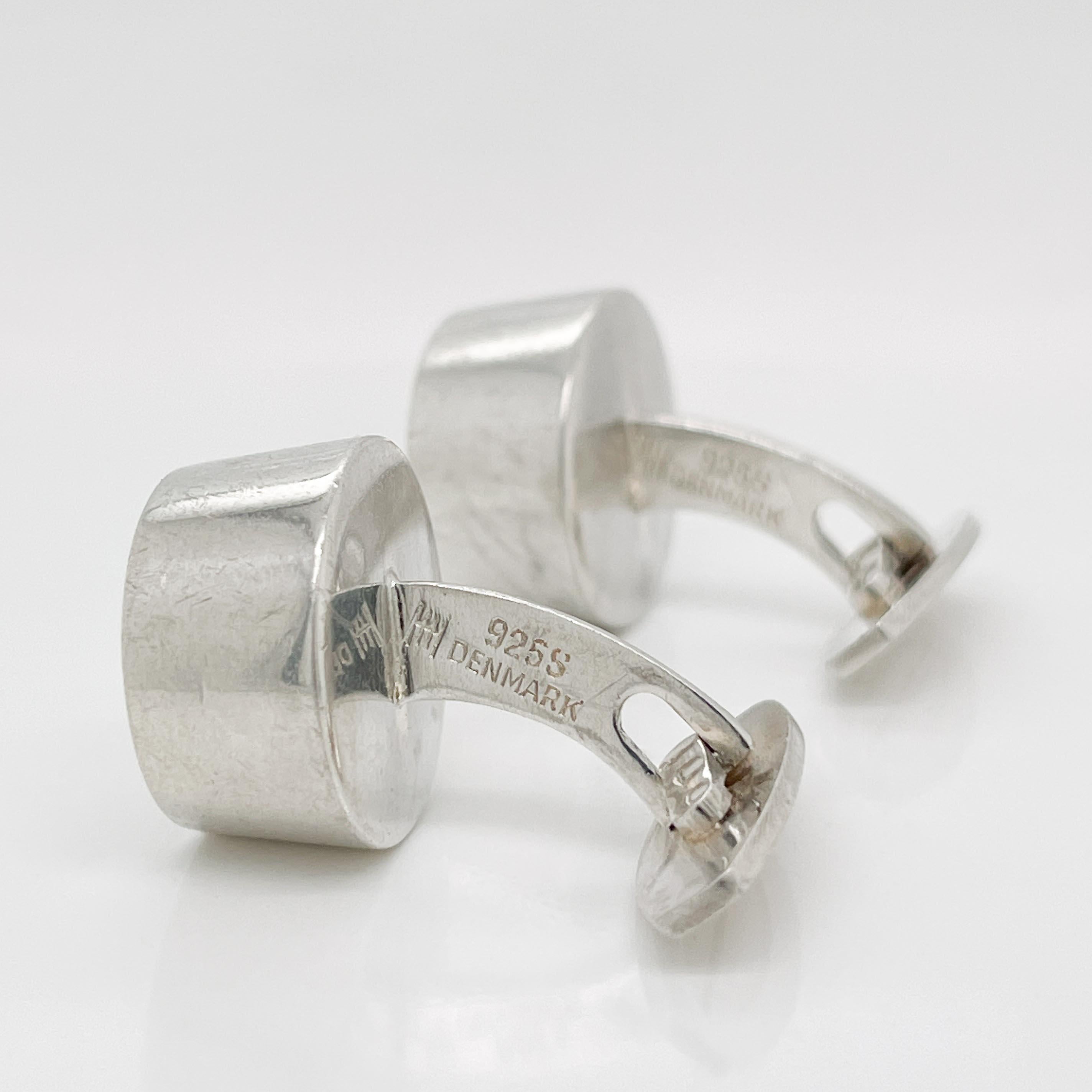 A fine pair of Mid-Century Modern cufflinks.

In sterling silver. 

By Hans Hansen. 

Model no. 642

With a button head, a fixed curved post, and a hinged catch.

Simply a wonderful pair of cufflinks from one of Denmark's masters!

Date:
Mid-20th