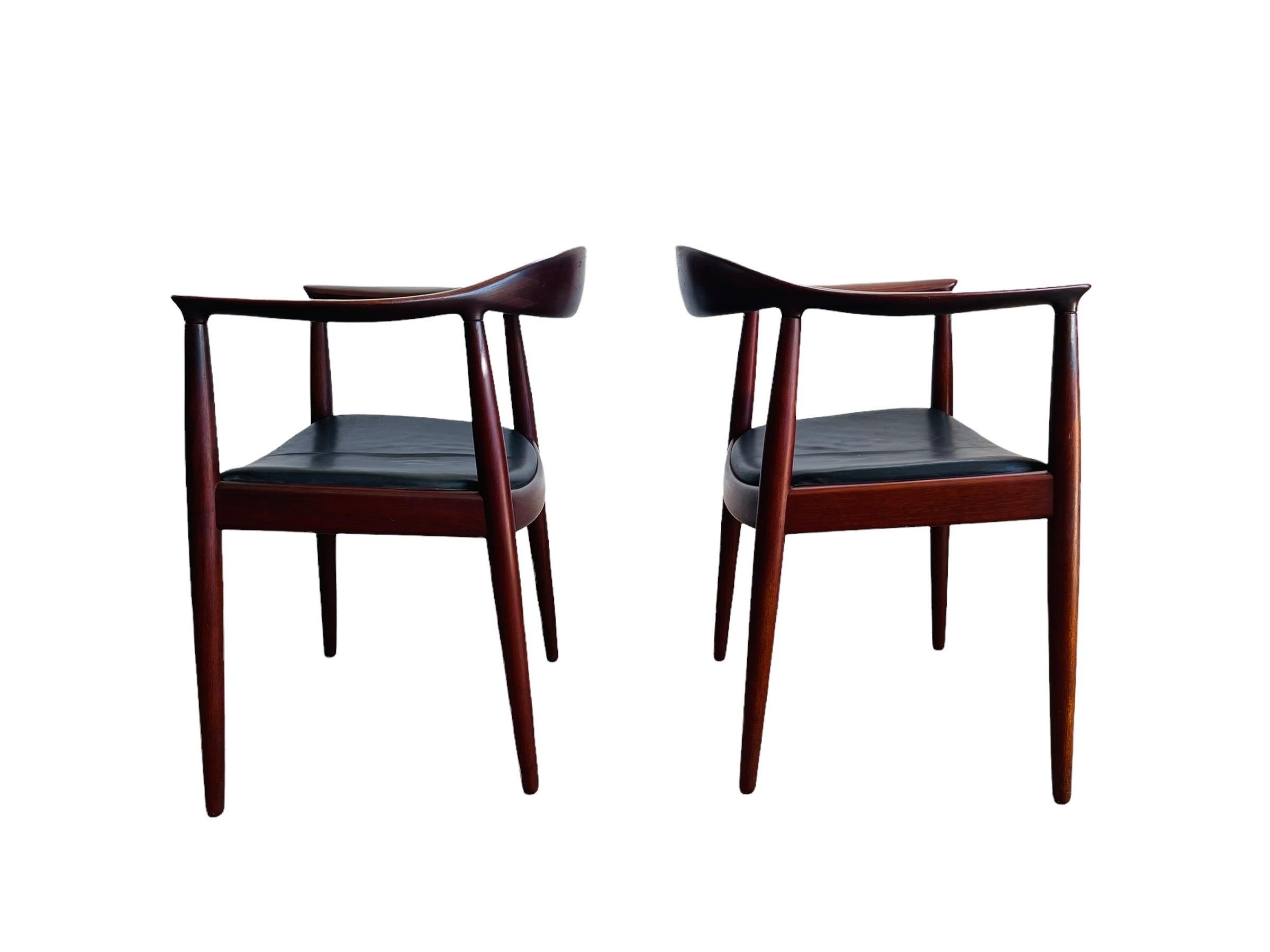 Stunning rare pair of Danish modern Teak chairs designed by Hans J. Wegner for Johannes Hansen circa 1954. The chairs are upholstered with original black leather on Teak frame. “The Chair” AKA 