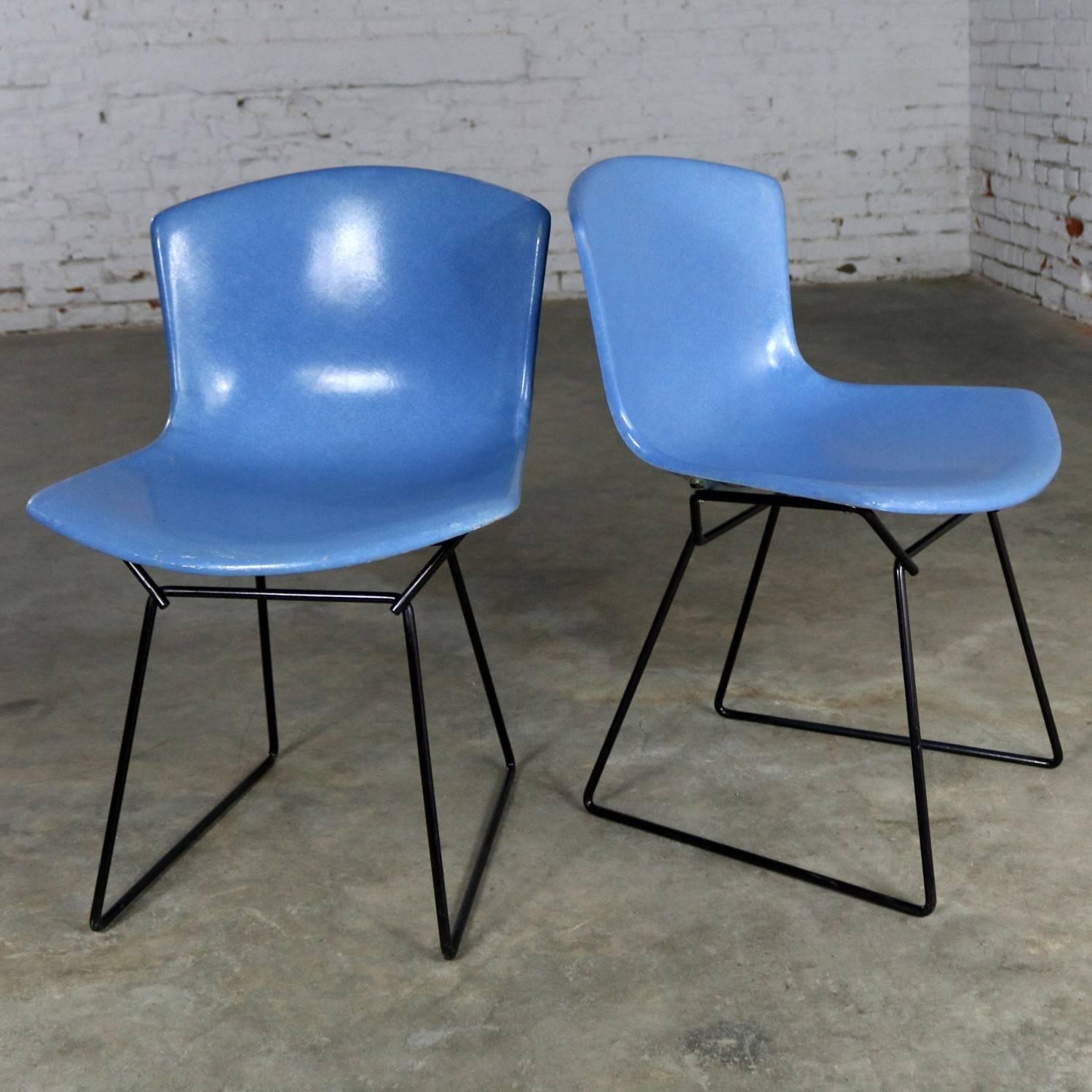 Handsome pair of Knoll Associates hard shell fiberglass side chairs by Harry Bertoia. These two are royal blue with a black wire base and retain their original tags. They are over-all in wonderful vintage condition. The shells are what we would