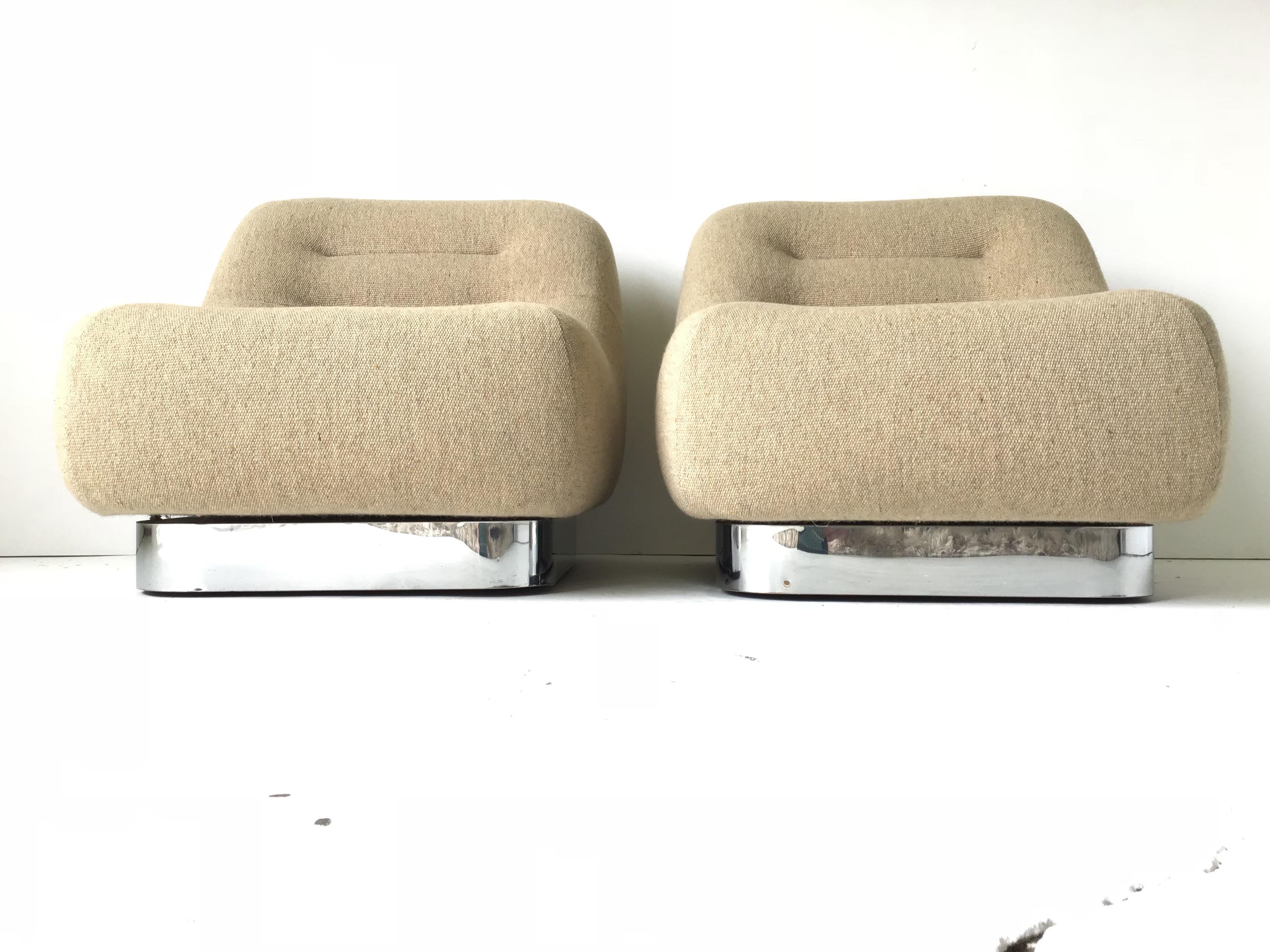 This is an absolutely fantastic pair of low lounge chairs. These obscure lounges are very sculptural sort of Space Age in design. They rest upon chrome plinths. They retain their original tan wool weave fabric. The “Tomorrow” collection is