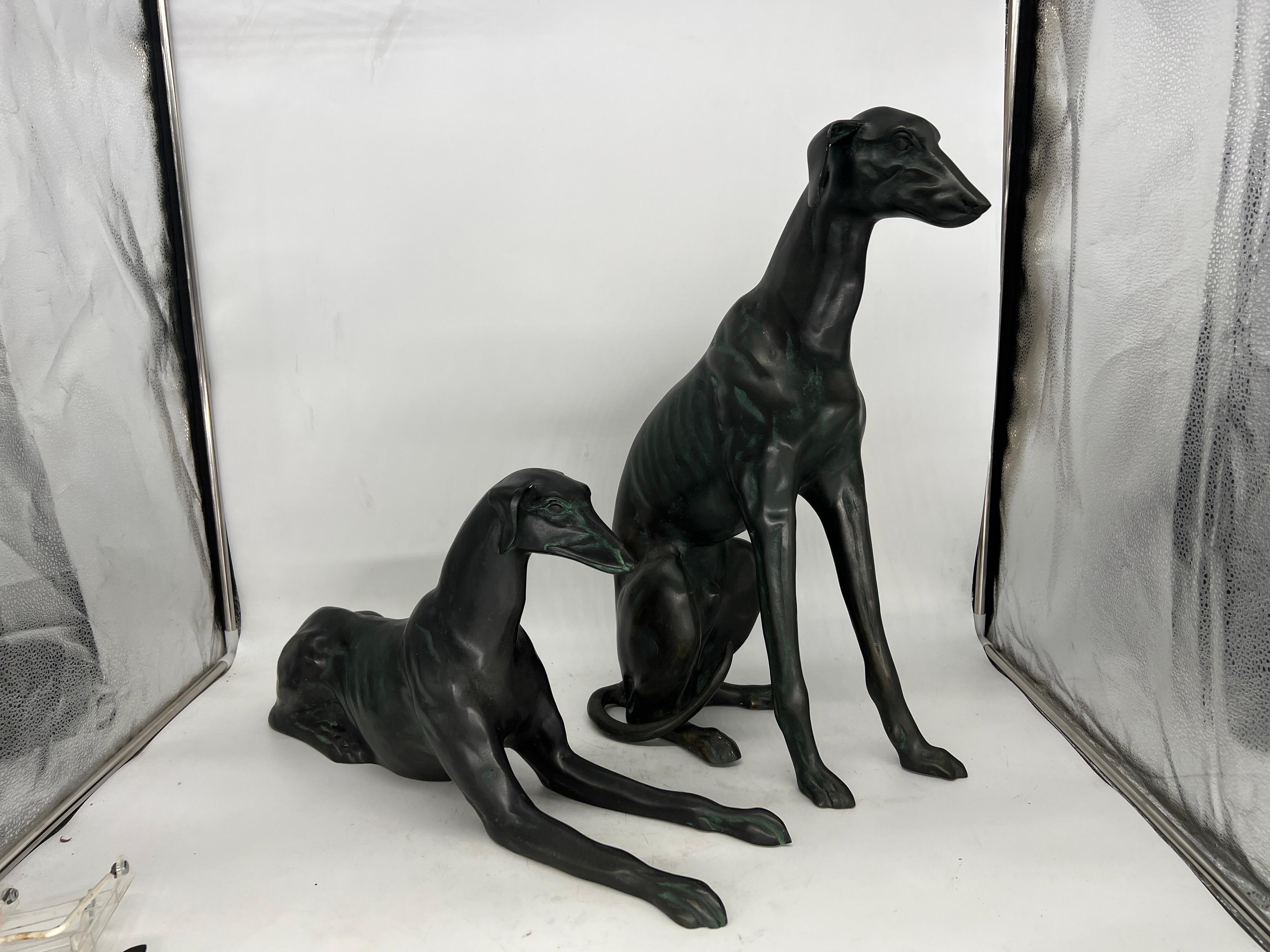 Paar, schwere Whippet-Hundestatuen aus Bronze.

Jede Statue ist aus hochwertiger Bronze gegossen, deren Oberfläche eine grüne Patina aufweist. Die Whippets messen:
Lg Hund - 22.75 h 8 b 14.5 d
kleiner Hund - 12.25 h 23 d 8 w