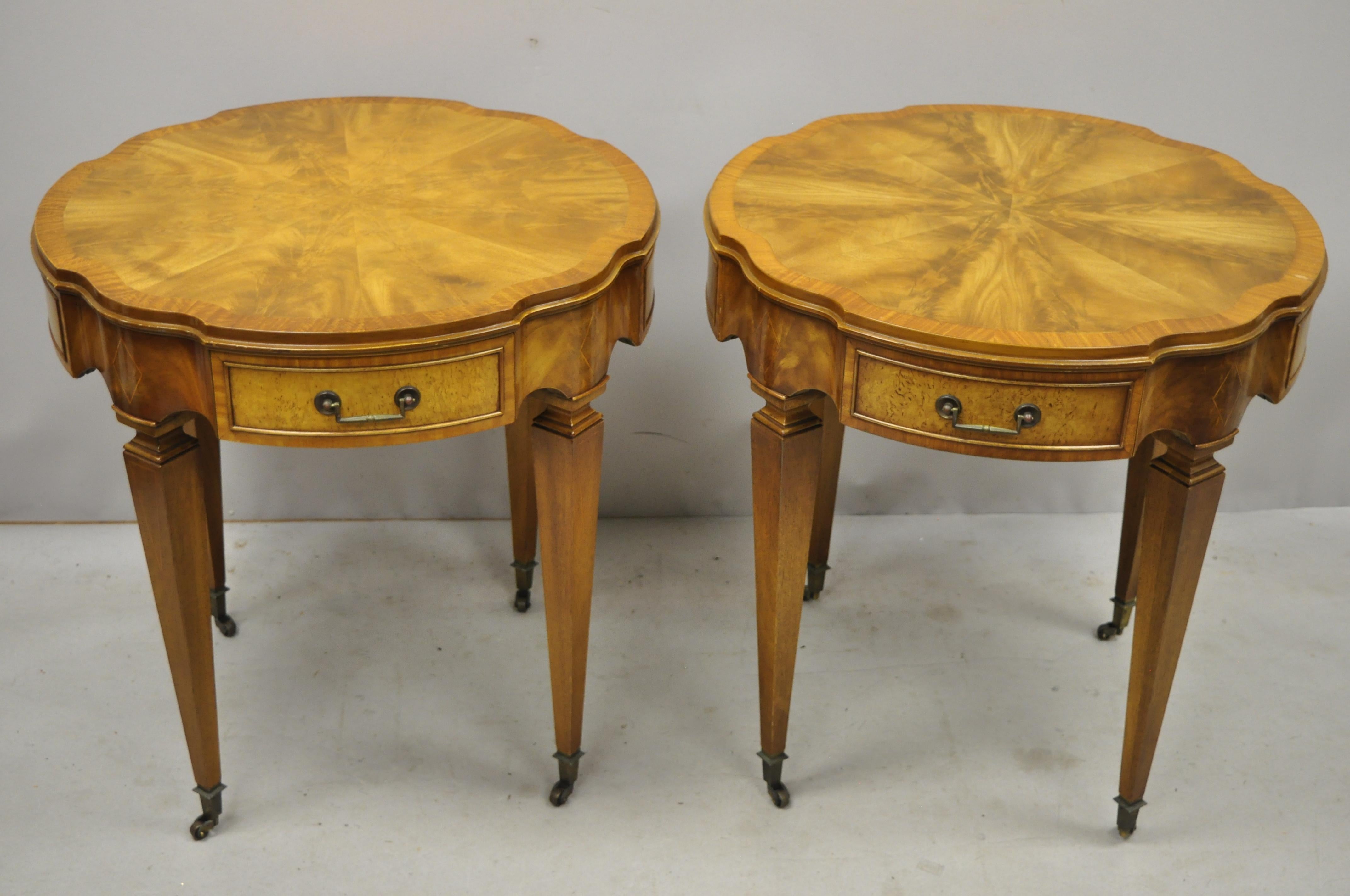 Pair of Heirloom Weiman crotch flame mahogany federal one drawer side end tables. Listing includes a custom glass top, brass rolling casters, diamond inlay to skirt and legs, finished back, 1 drawer, tapered legs, solid brass hardware, quality