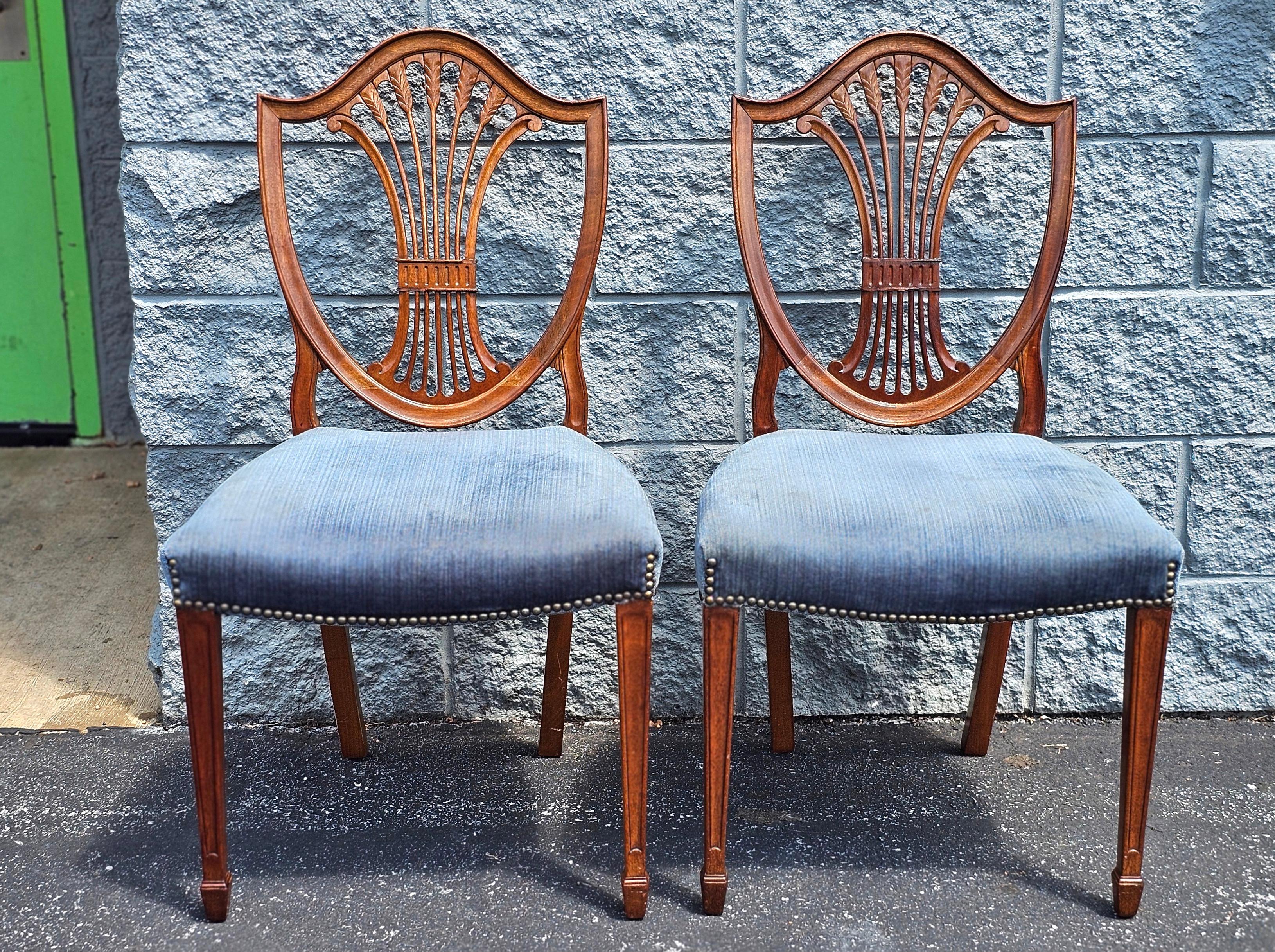 A Pair of Early 20th Century Hepplewhite Style Mahogany and Upholstered Shield Back Side chairs, with large curved seats with nail hard trims.
Measures 21 