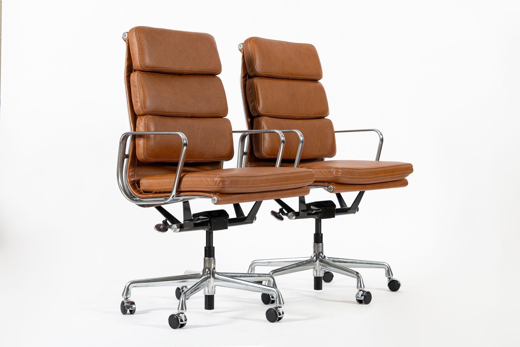 These authentic Eames for Herman Miller Soft Pad Executive Height office chairs from the Aluminum Group Collection were manufactured in the 2000s. These executive height chairs feature a taller backrest, brown leather upholstery, polished aluminum