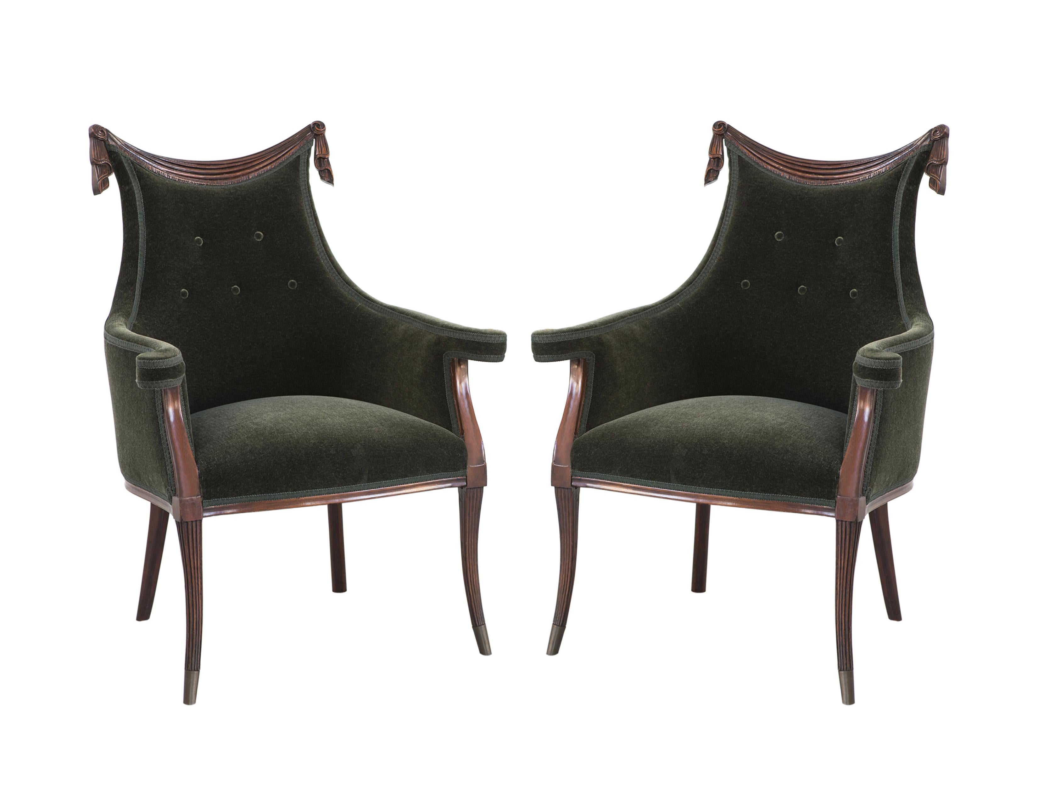 Bringing new life to the classic! Stunning pair of 1940's Hollywood Regency chairs by Grosfeld House. Each chair in ebonized walnut and features a hand-carved draped design top stile, button detailed tufted back support and the armrests upholstered