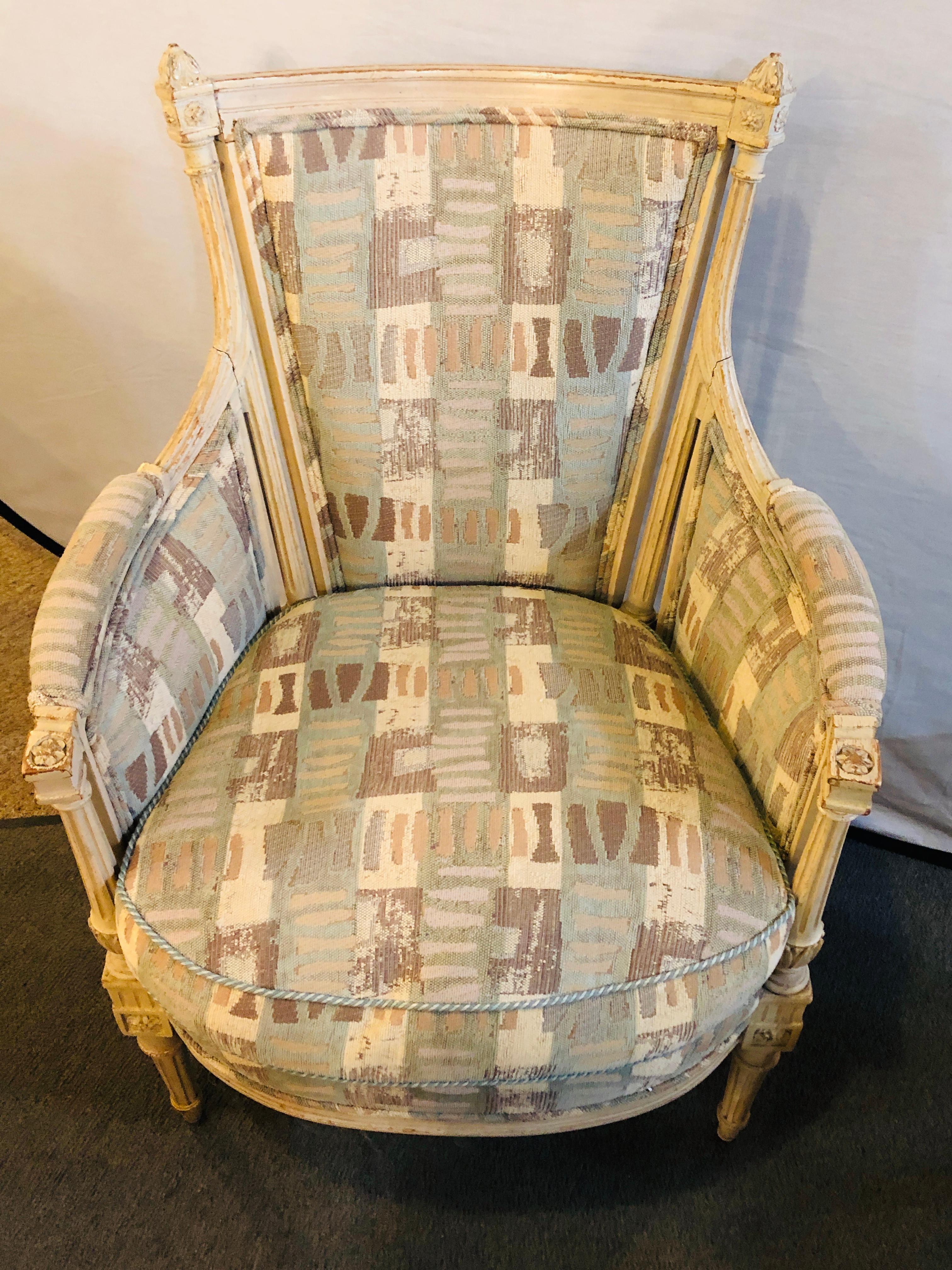 Pair of Hollywood Regency Maison Jansen bergere or armchairs beautifully re-upholstered. Done in a distressed Swedish finish these fine Louis XVI Style chairs are simply stunning and are sure to add elegant style to any home decor. Typical in style