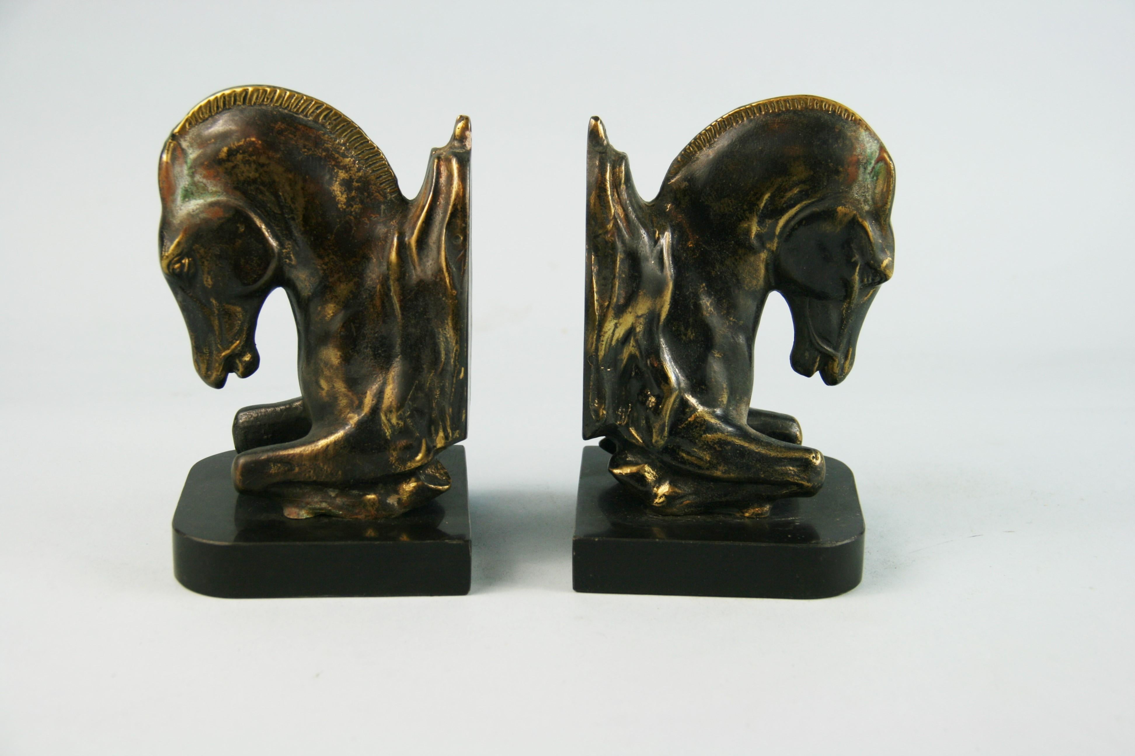 3-637 Pair of cast metal bookends on black marble base.