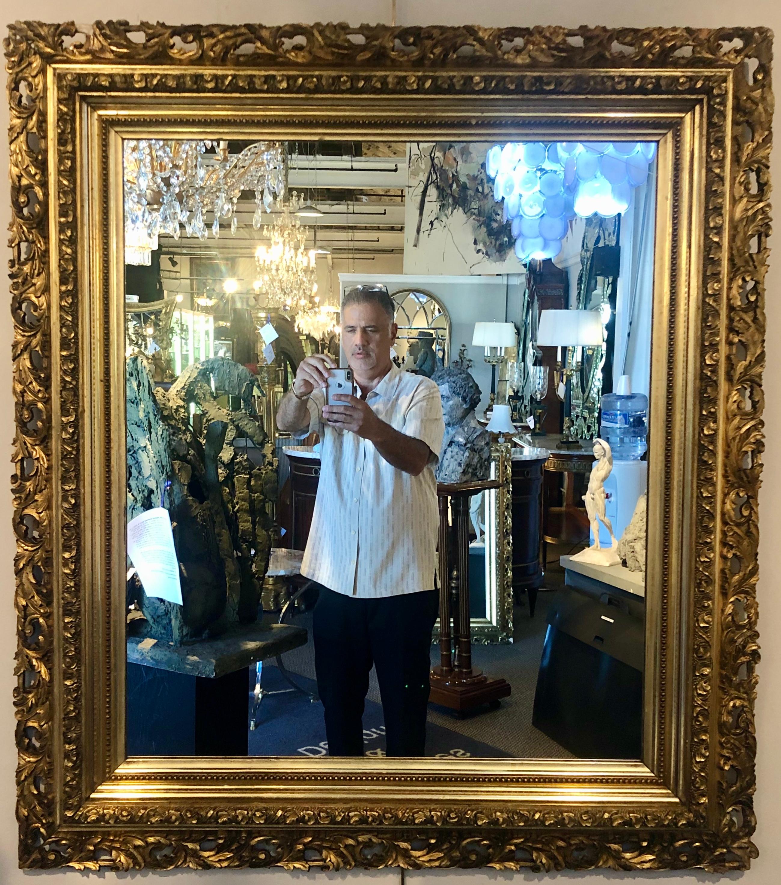 Pair of giltwood late 19th century wall or console mirrors. Each having a clear center mirror framed in a finely carved giltwood pierced carved frame. The six border gilt frame is simply stunning and would make a lovely addition to any home setting.