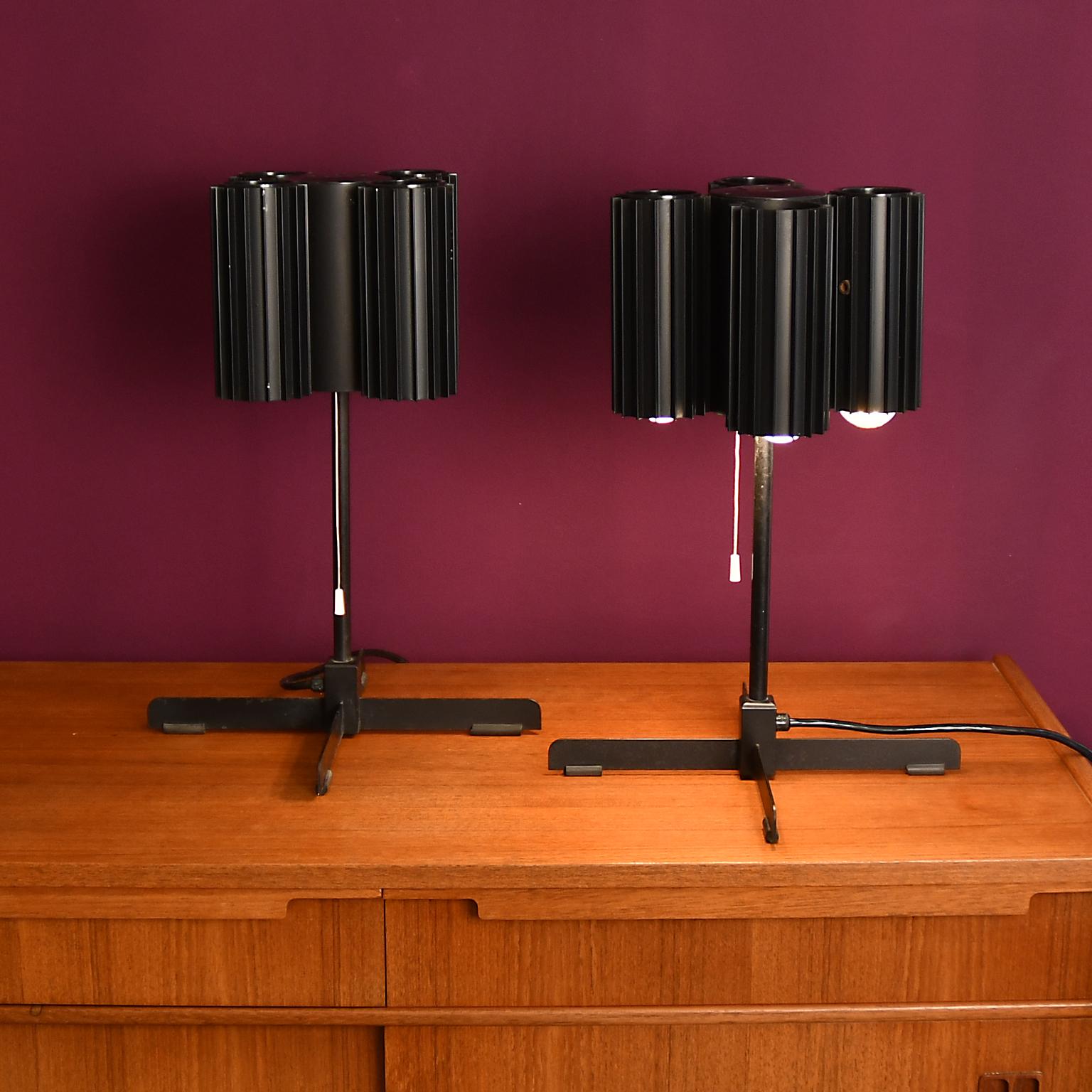 Lampe de table en métal, peinte en noir, état original.
La paire est attribuée à J. T. Kalmar vers 1970. 4 tubes métalliques cannelés, intérieur partiellement manquant de la laque noire. Chacun 4 douilles E27 avec bord en porcelaine. Nous