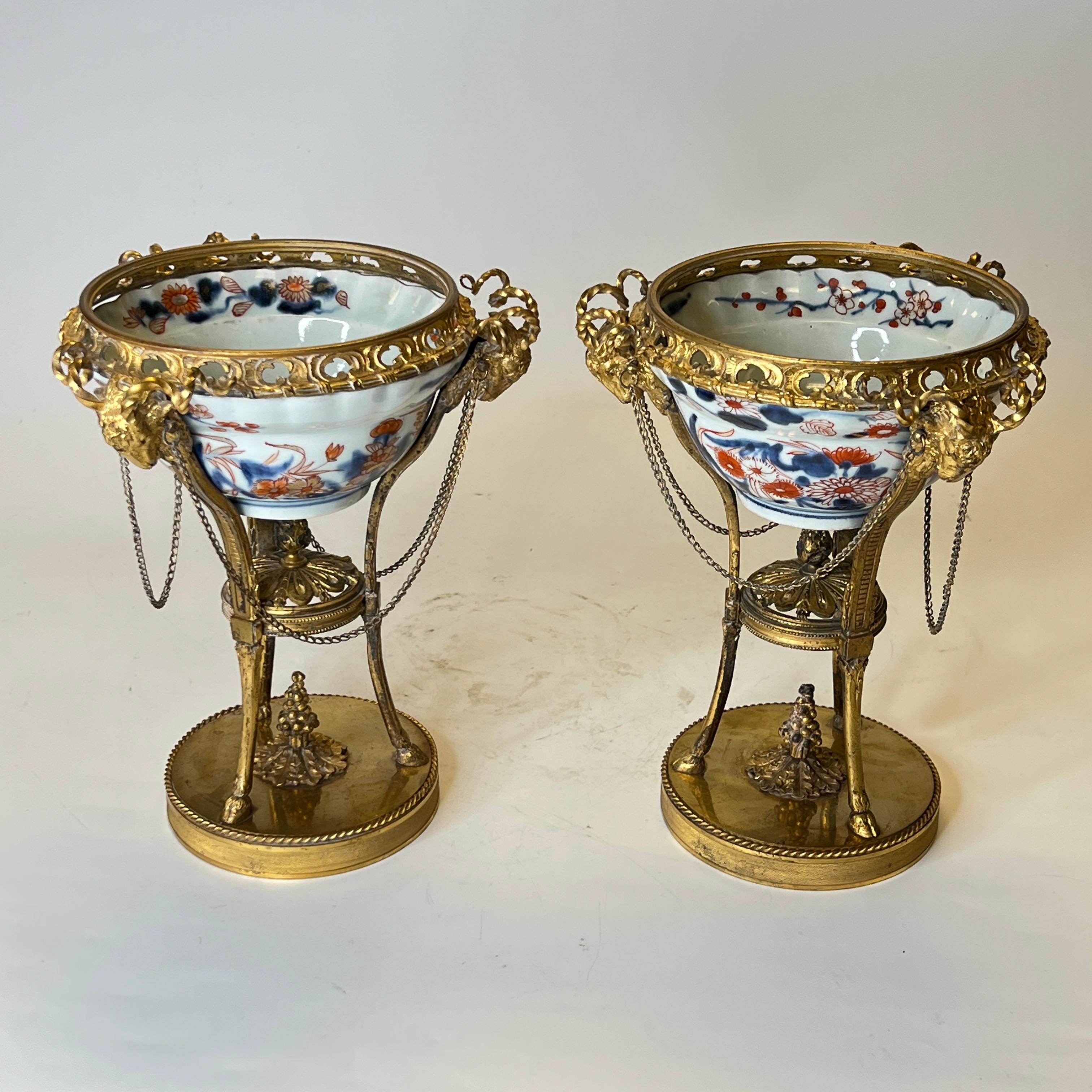 Pair early 19th century Chinese Imari porcelain bowls with ormolu bronze torchiere-form stands in Louis XVI Style.