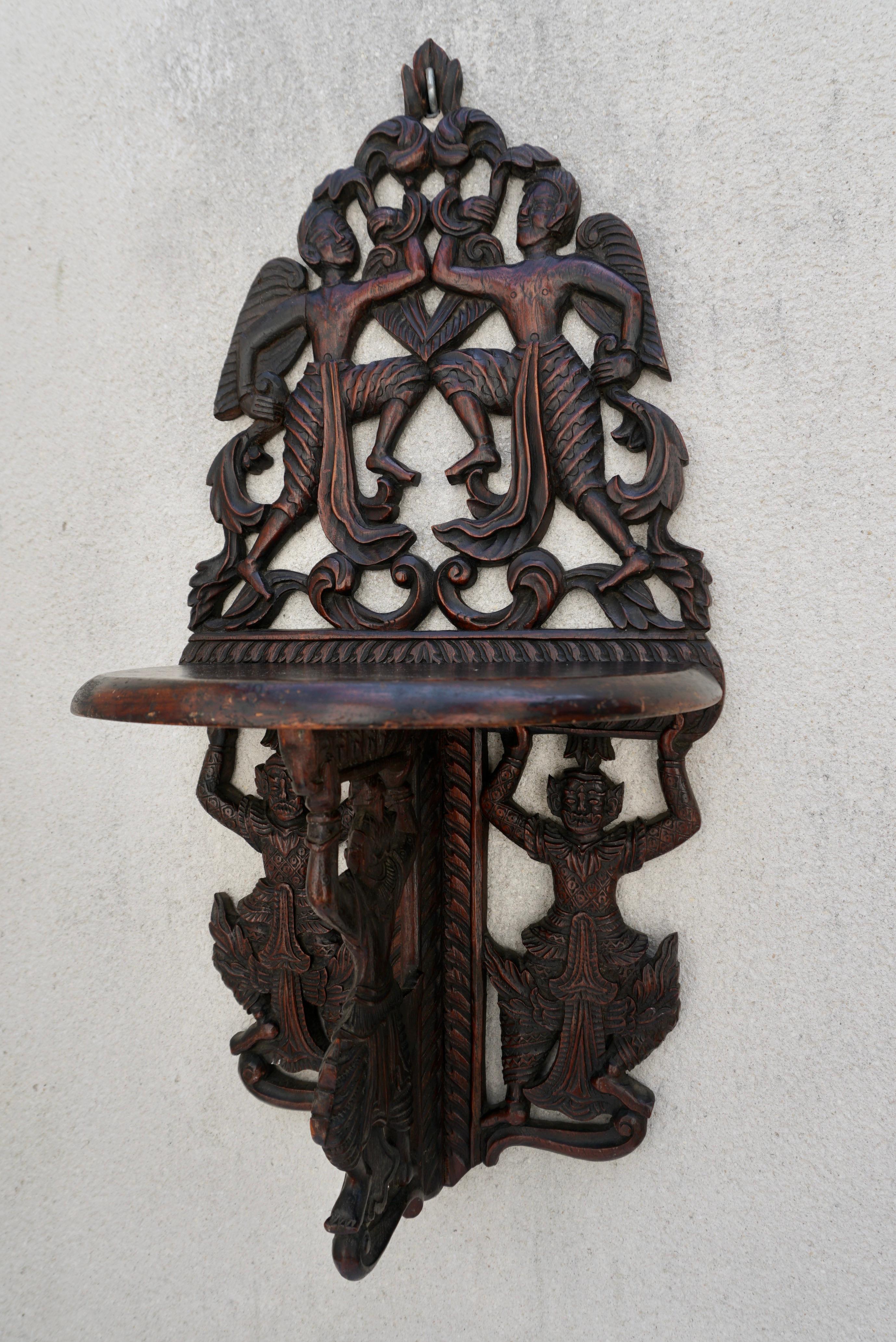 Pair Indonesian carved figural wall console brackets.

Pair Indonesian carved Figural wall brackets, carved with winged figures and dancing demons, with hinged shelf and bracket.
 
 Dimensions: 28 x 14 x 11 in.
 
 Condition: Some age related wear