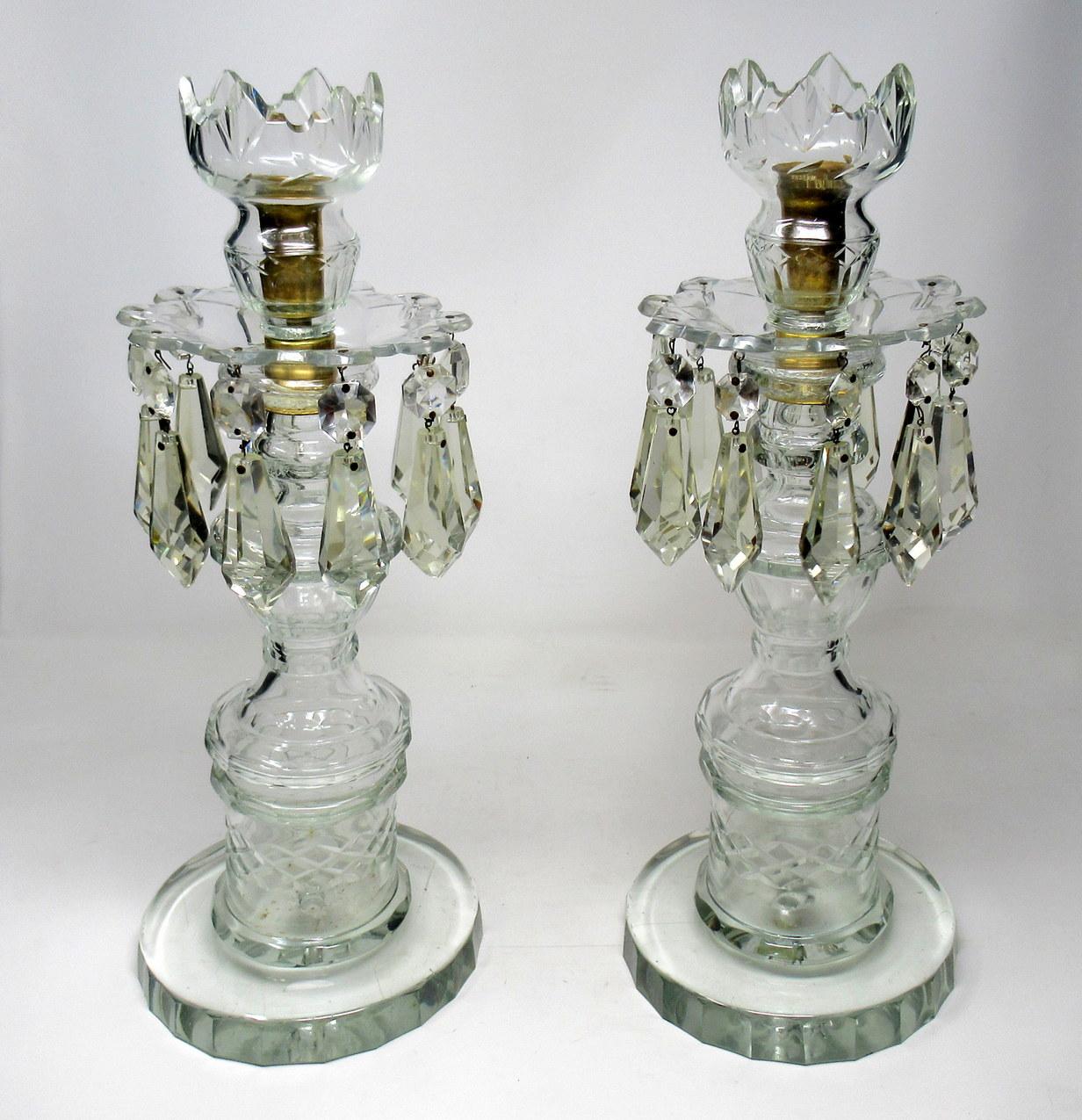 A stunning and imposing pair of Irish old Waterford glass handcut full lead crystal single light candlesticks lustres of outstanding quality, first half of the 19th century.

The central waisted support above a decorative socle ending on a deep