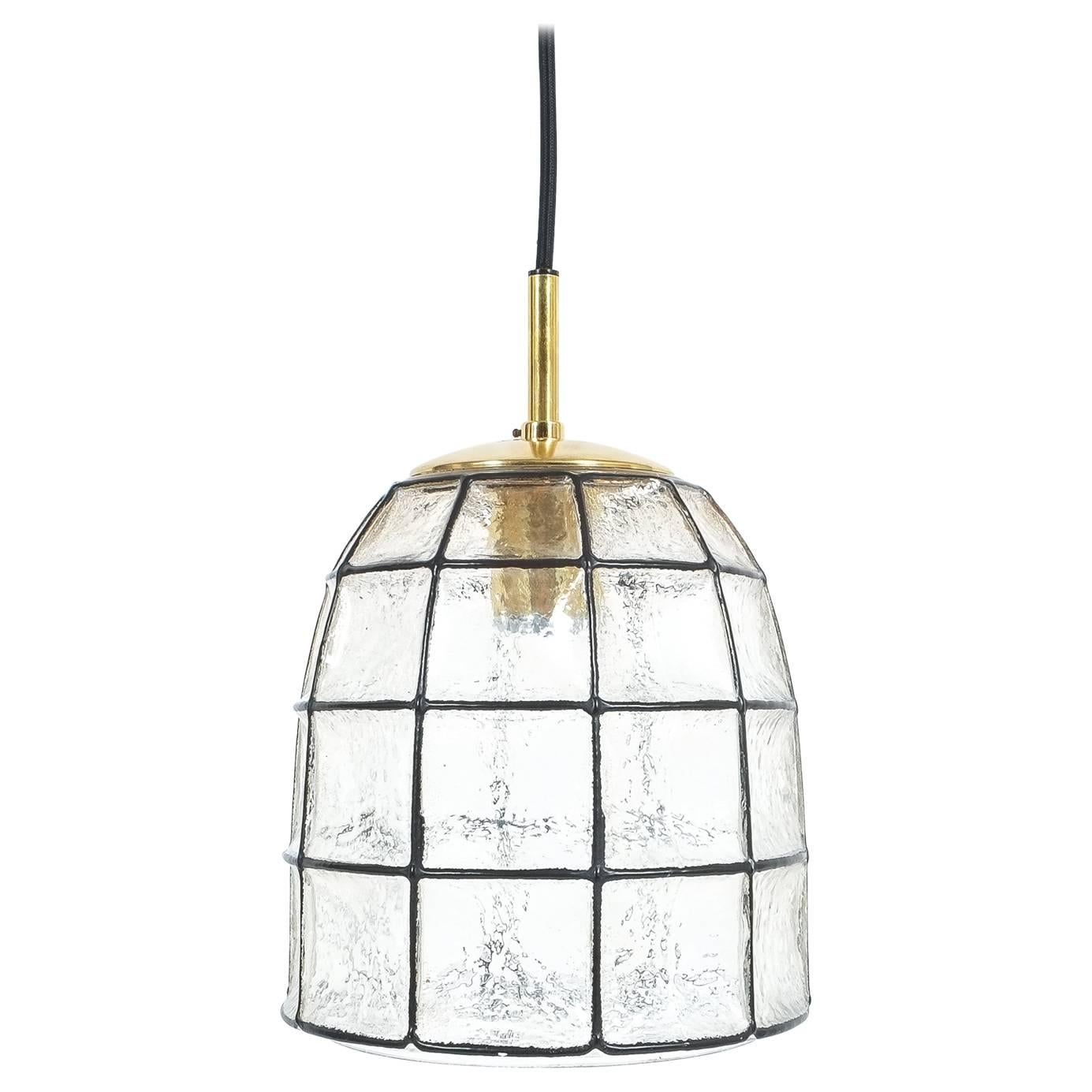 Pair of 'iron' and glass bell-shaped pendant light by Limburg, Germany. The fixtures feature a concave thick clear glass shade with rectangular black accent 'iron' elements. The hardware is made from polished brass. It holds a single large bulb