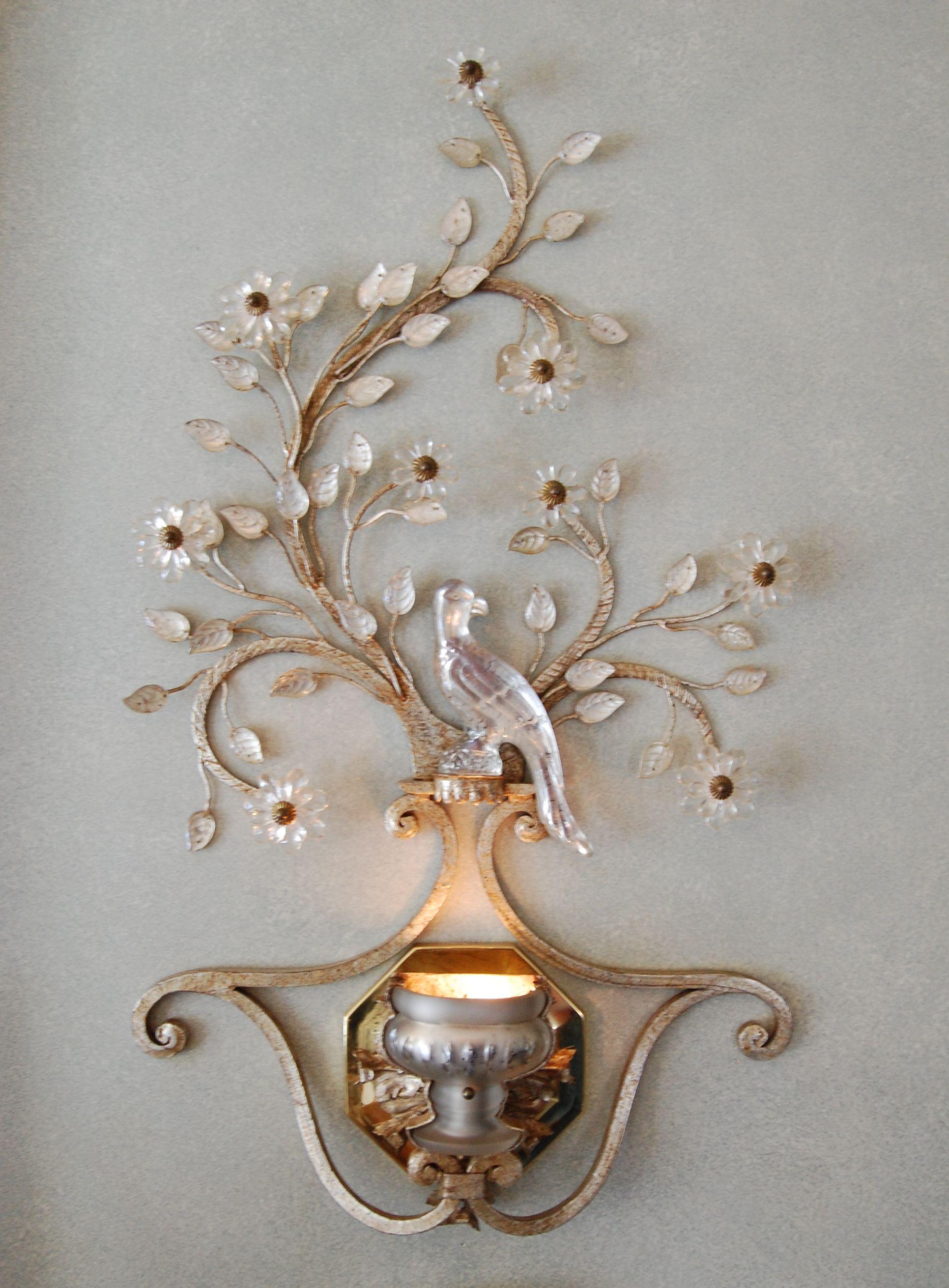 A pair of large Art Deco style sconces with crystal birds, flowers and leaves, on a silver poly-chromed iron frame with a brass octagonal backplate. Internal bulbs provide up-light. These fixtures have not been produced by the manufacturer for many