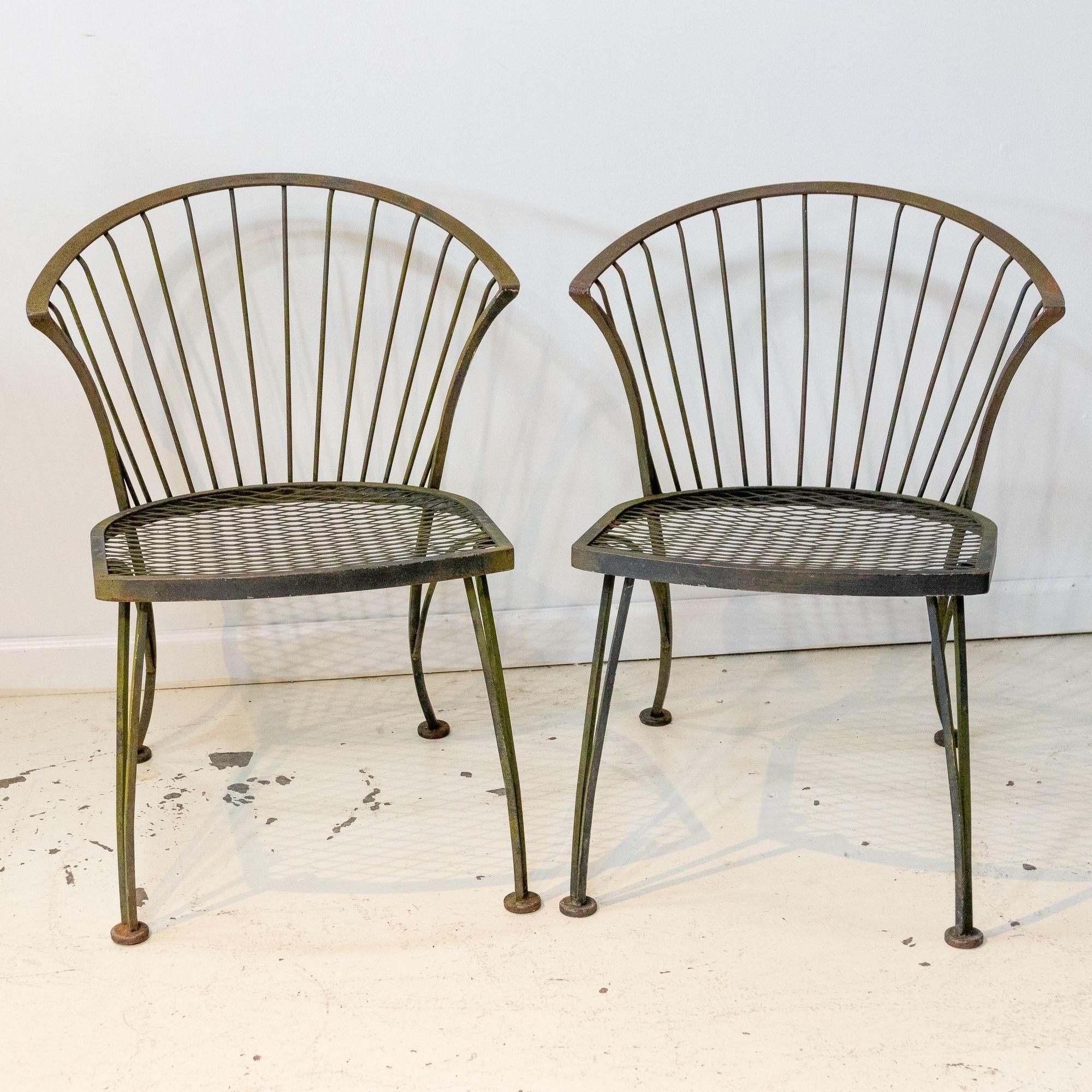 Circa mid-20th century pair of iron garden chairs with curved back and vertical slats. The seat also features a diamond cross hatch pattern. 17