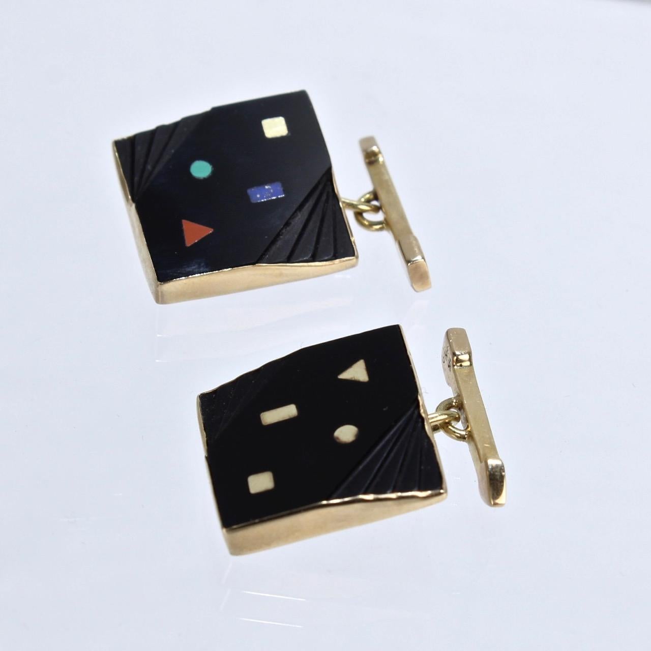 A very fine set of bezel set onyx and gold cufflinks by Isabelle Posillico in the 1980's Memphis school style.   

Each with bezel set square onyx gemstones that have stepped, angular cuts to the side and are inset with gold, coral, lapis and