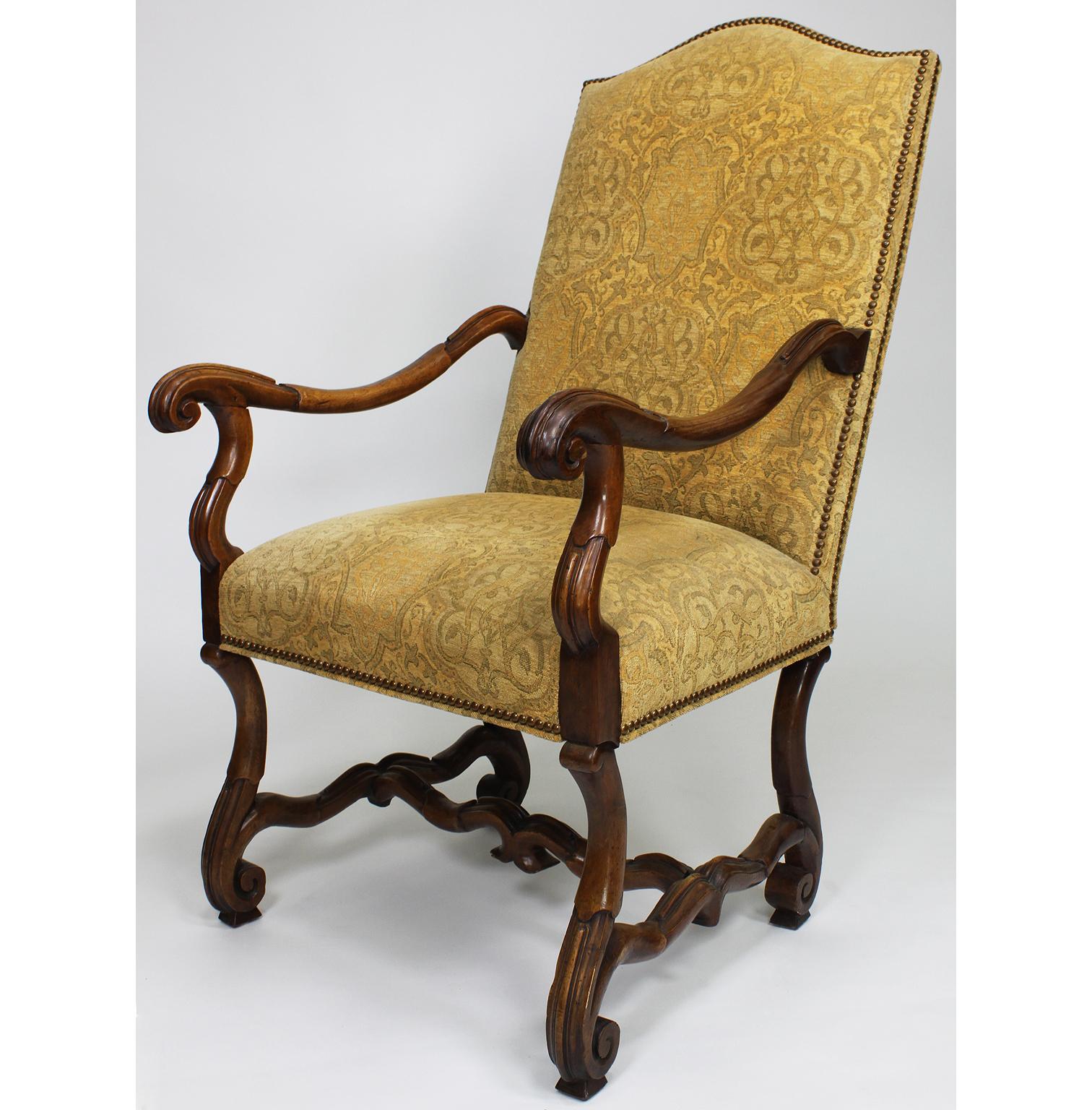 A fine pair of Italian 19th century Baroque Revival style carved walnut throne armchairs. The high-back frames with recent upholstered back and seat and open carved scrolled armrests raised on four conjoined cabriolet carved legs. The fabric is