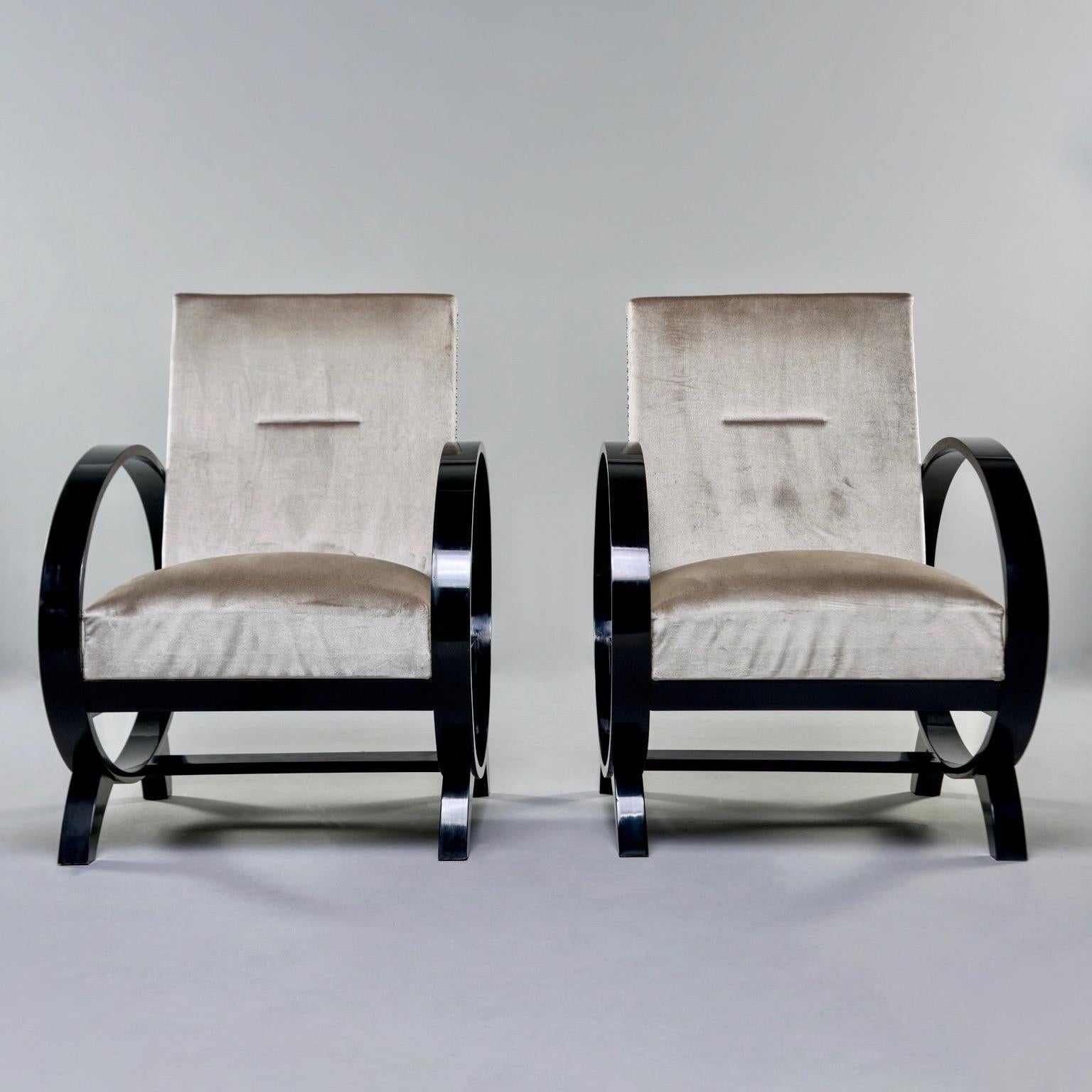 Pair of Italian Art Deco lounge chairs feature dramatic, oval wood arms, circa 1940s. Frames have black finish and newly upholstered in a sand colored velvet with a bit of sheen. Silver tone nailhead trim. Unknown maker. Sold and priced as a