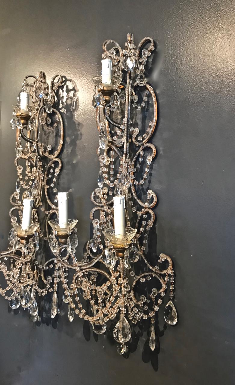 This is a superb pair of 33 inch Italian beaded sconces that dates to the mid-20th century. The sconces are detailed with multiple macaroni beaded swags; gold leafed brass arms; abundant faceted glass tear drop pendants. The electrical fittings have