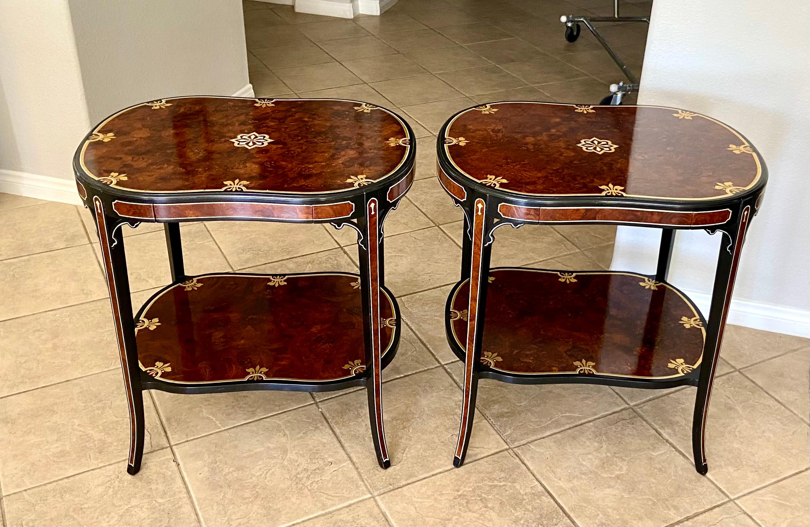 Italian burlwood 2 tier contoured rectangle shape side or end tables, each with a pull draw. The burlwood veneer has a glossy rich brown & redish tone, complimented with black and delicate gold stencil detailing.