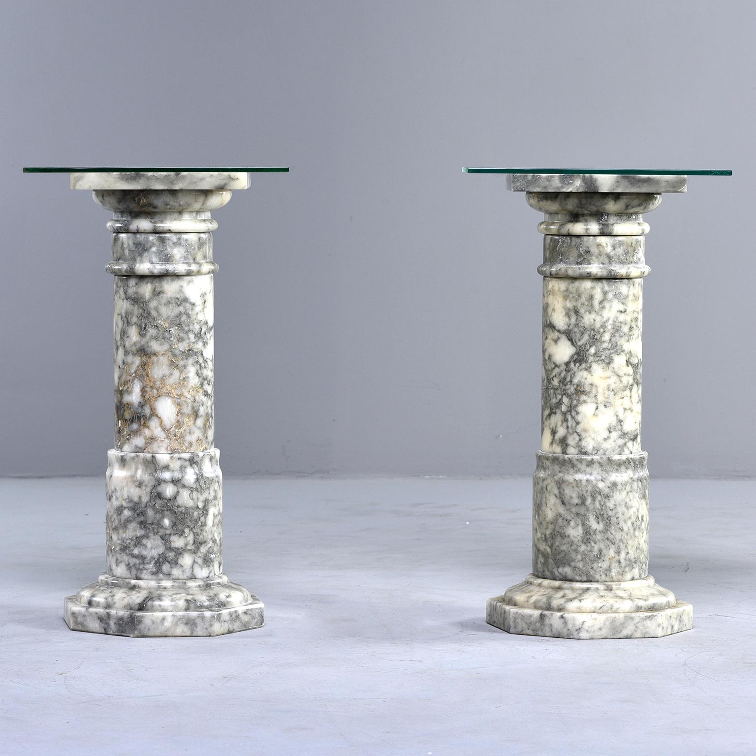 Pair of Italian Carved Marble Columns

Custom made for us in Italy, this pair of carved columns is made of gray and cream colored marble. Use as is with square tops for plant stands or use the columns as supports for a single table or with smaller