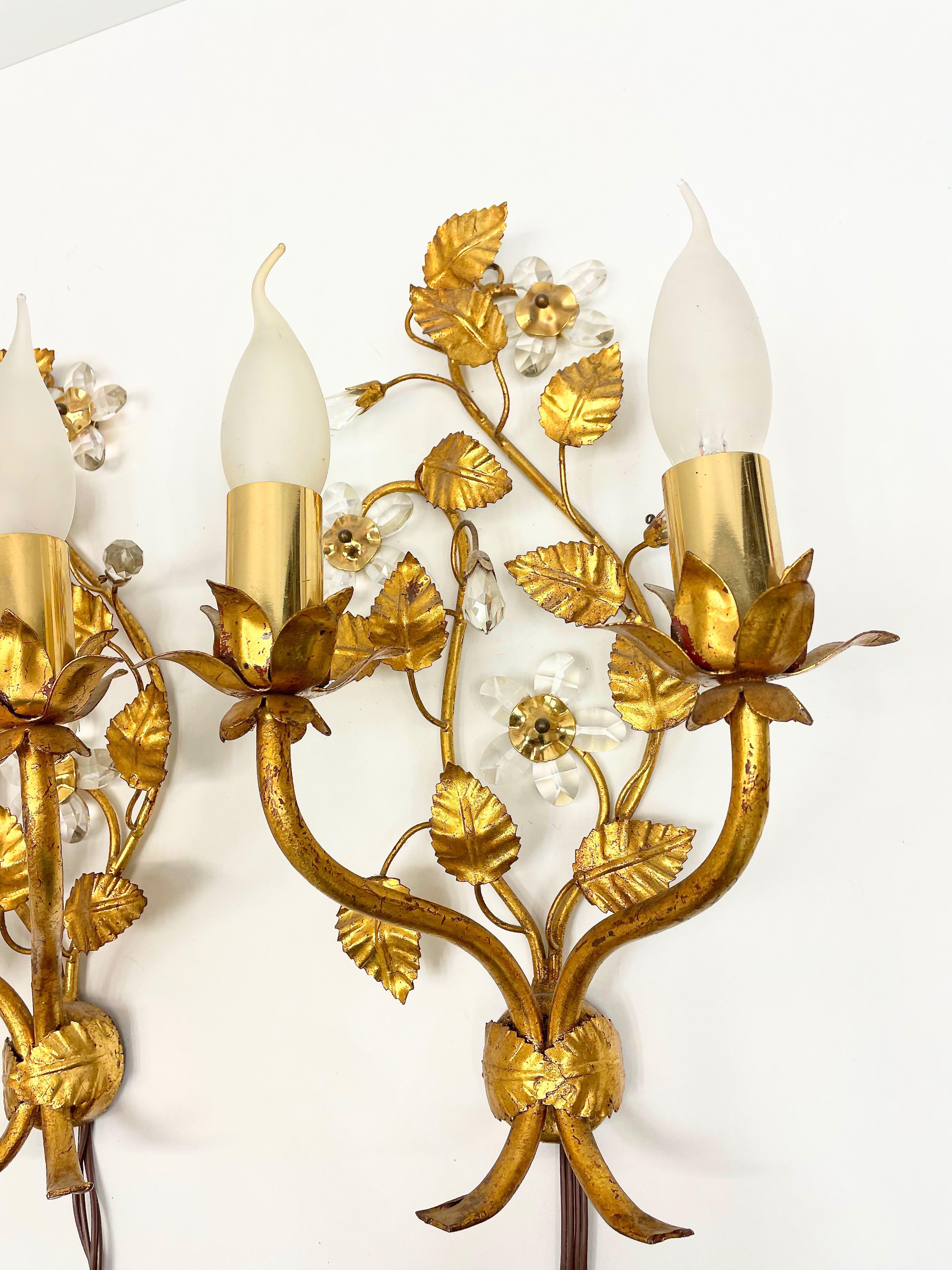 A pair iron gilded floral sconce by Banci Firenze with crystal flowers and leaves. Each fixture requires two European E14 candelabra bulbs, each bulb up to 40 watts. The wall light has a beautiful patina and gives each room an eclectic statement.