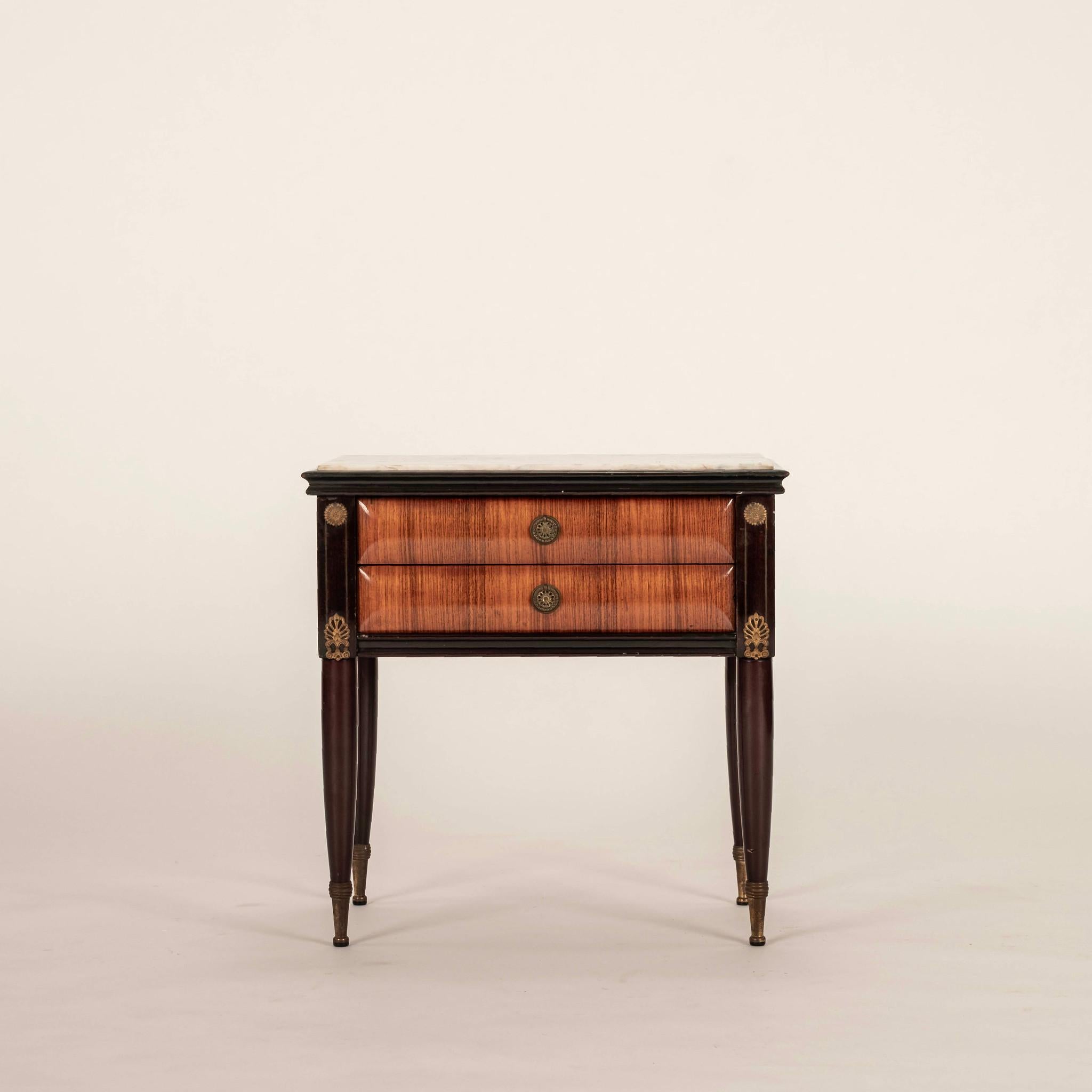 Pair of 1960s Italian Directoire style two drawer nightstands feature lacquered wood, white marble top with brass ormolu and hardware. 