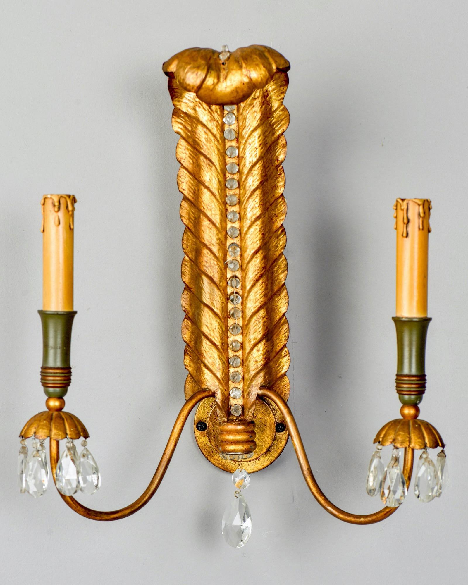 Italian gilt metal sconces in form of feather or curled leaf with beaded center, two candle style lights and crystal drops suspended from bobeches, circa 1920s. New electrical wiring for US standards. Sold and priced as a pair.


   