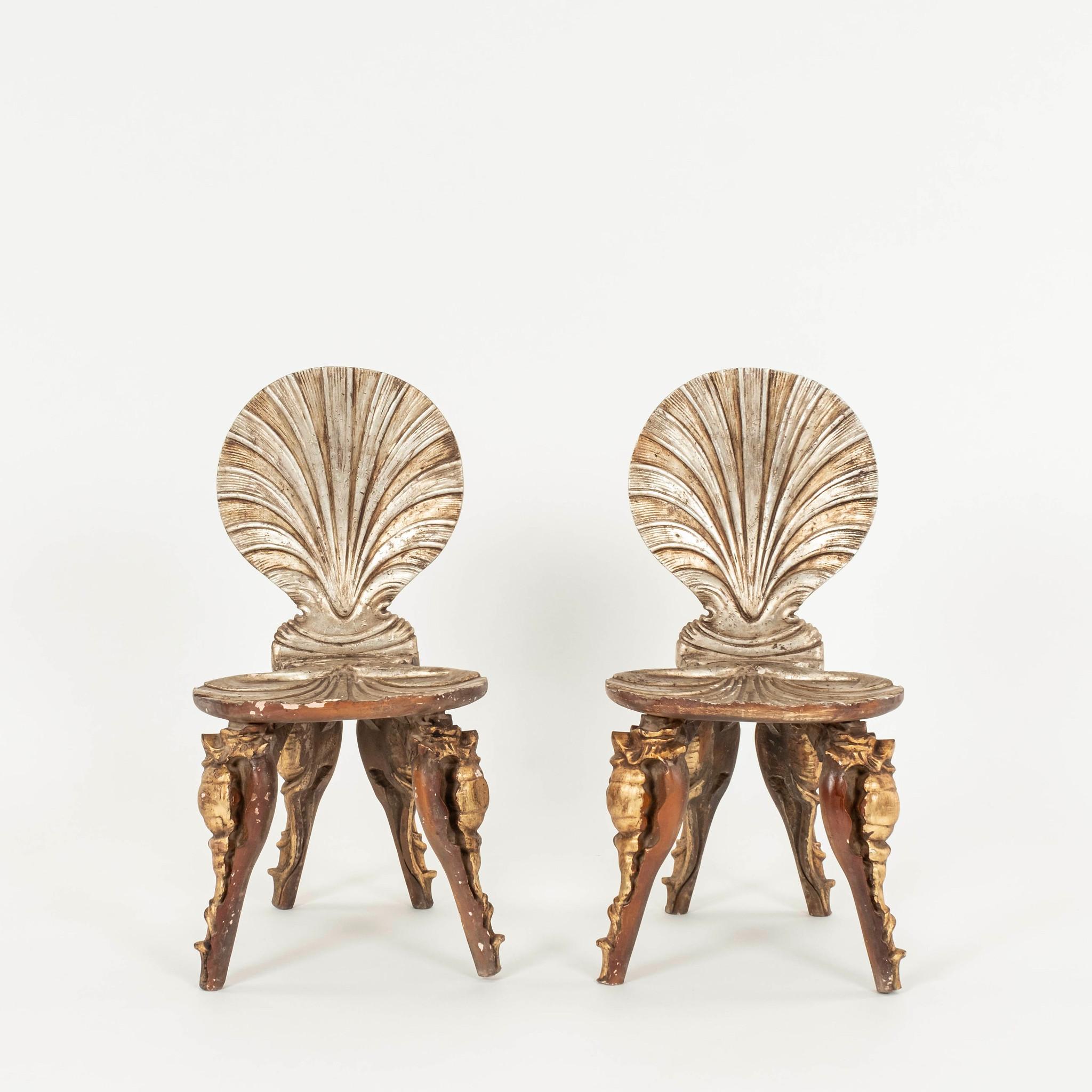 An iconic pair of 20th Century silver gold Italian giltwood grotto chairs with clamshell seat and back supported by beautifully carved conch legs.