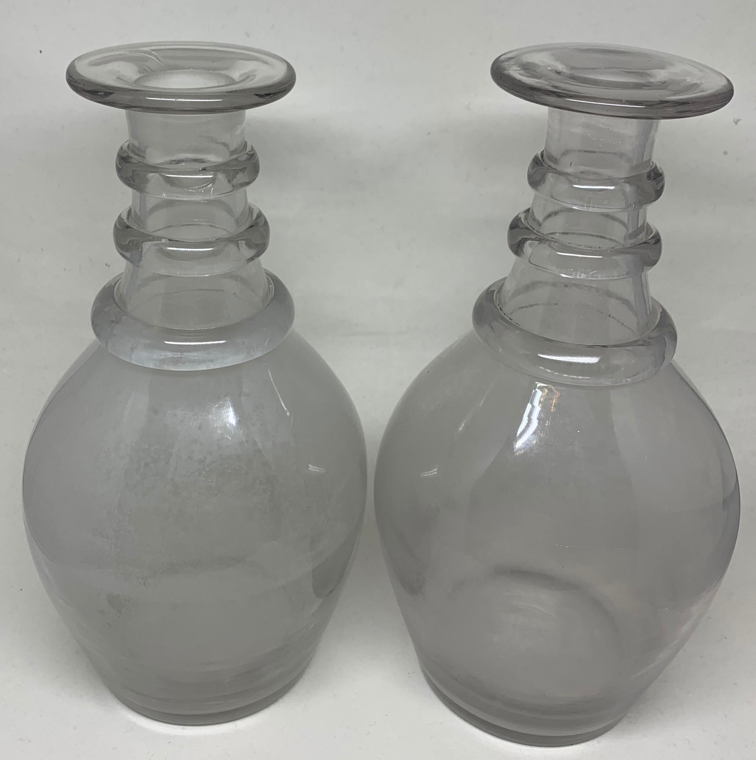 Pair Italian hand blown ring neck bottles. Vintage pair Murano clear glass bottles with three bands at the neck, interior clouding from use. Italy, 1930s
Dimensions: 9.25