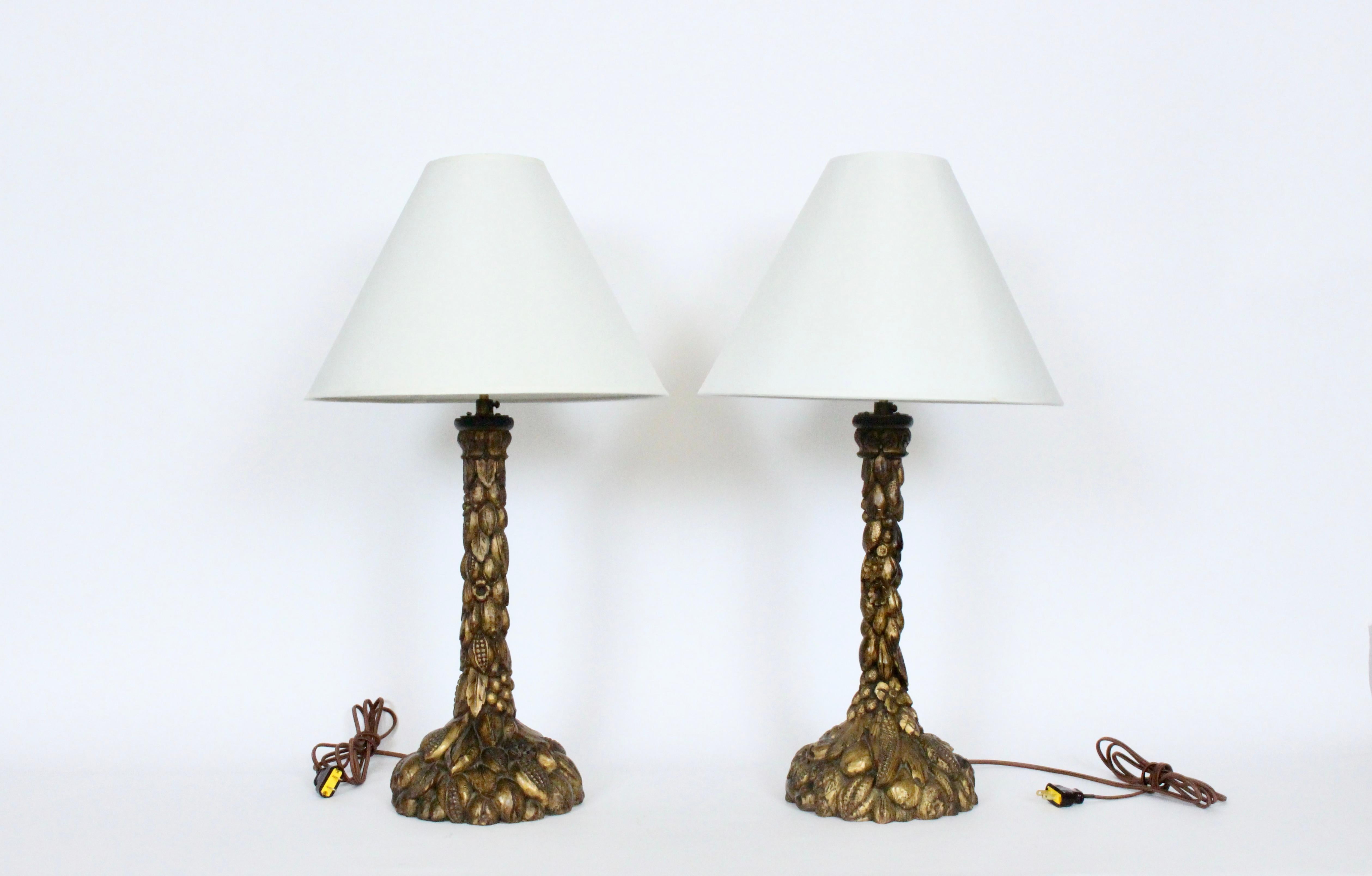 Early 20th Century handcrafted Italian Flora Motif Gilt Wood Table Lamps. Featuring delicate hand carved natural seed pods, flowers, leaves, berries and nuts, extending to each base with Golden highlights throughout. 17H to top of Wood. With double