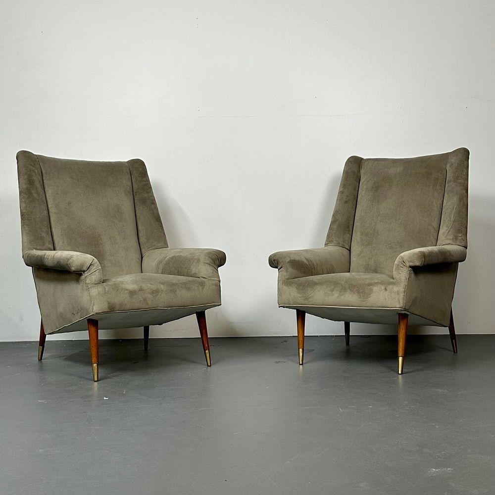 Pair Italian Mid-Century Modern lounge or wing back chairs, Gio Ponti Style, velvet, walnut.

Handsome pair of unsigned Italian lounge chairs of the mid-century period. Having curved walnut legs finished with a light polish and brass sabots on all