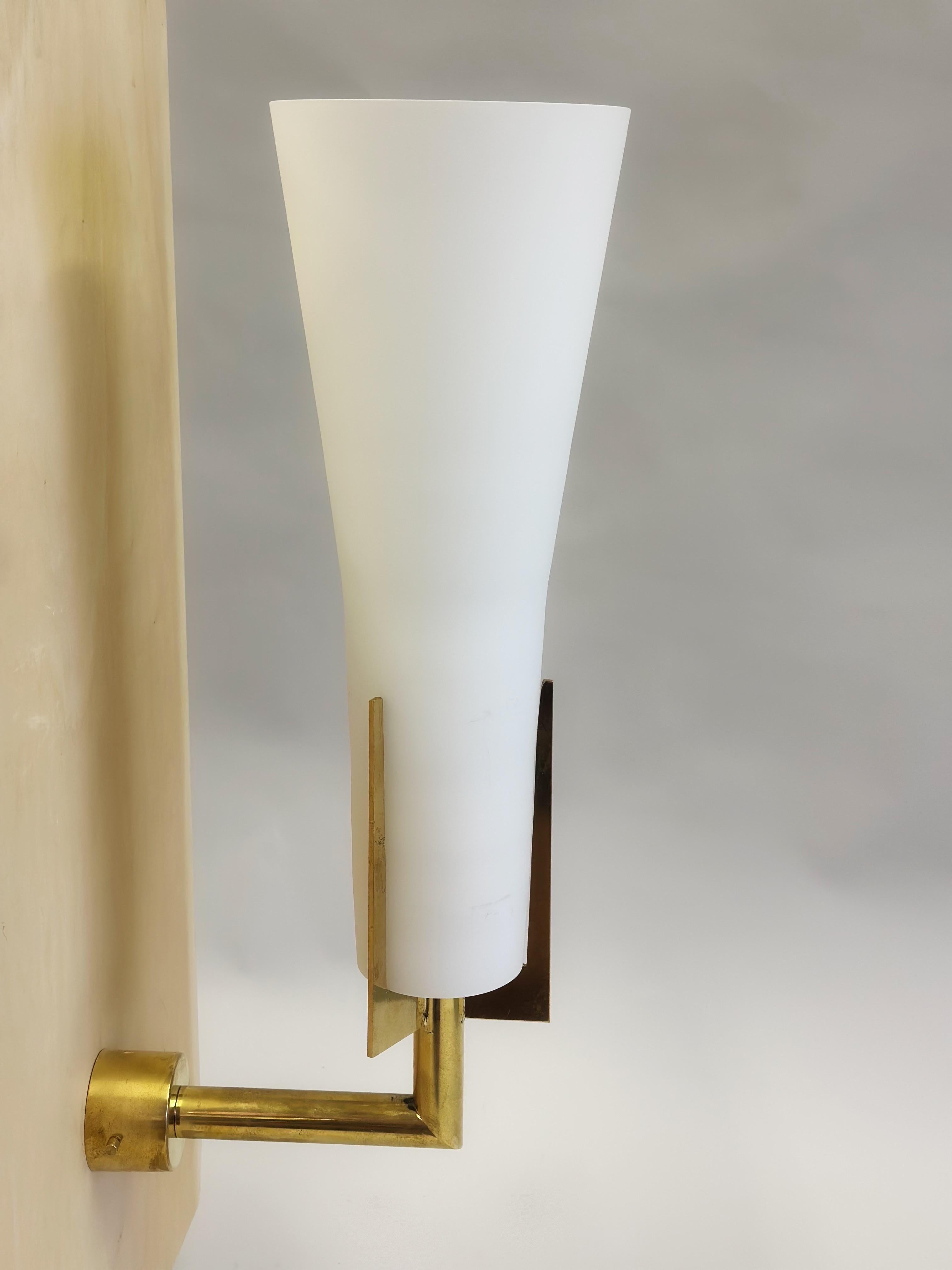 An elegant and timeless pair of Italian mid-century wall sconces attributed to Max Ingrand and Fontana Arte. The sconces are in the Modern Neoclassical style and are of rare design and the highest quality of manufacture. They feature a hand sculpted
