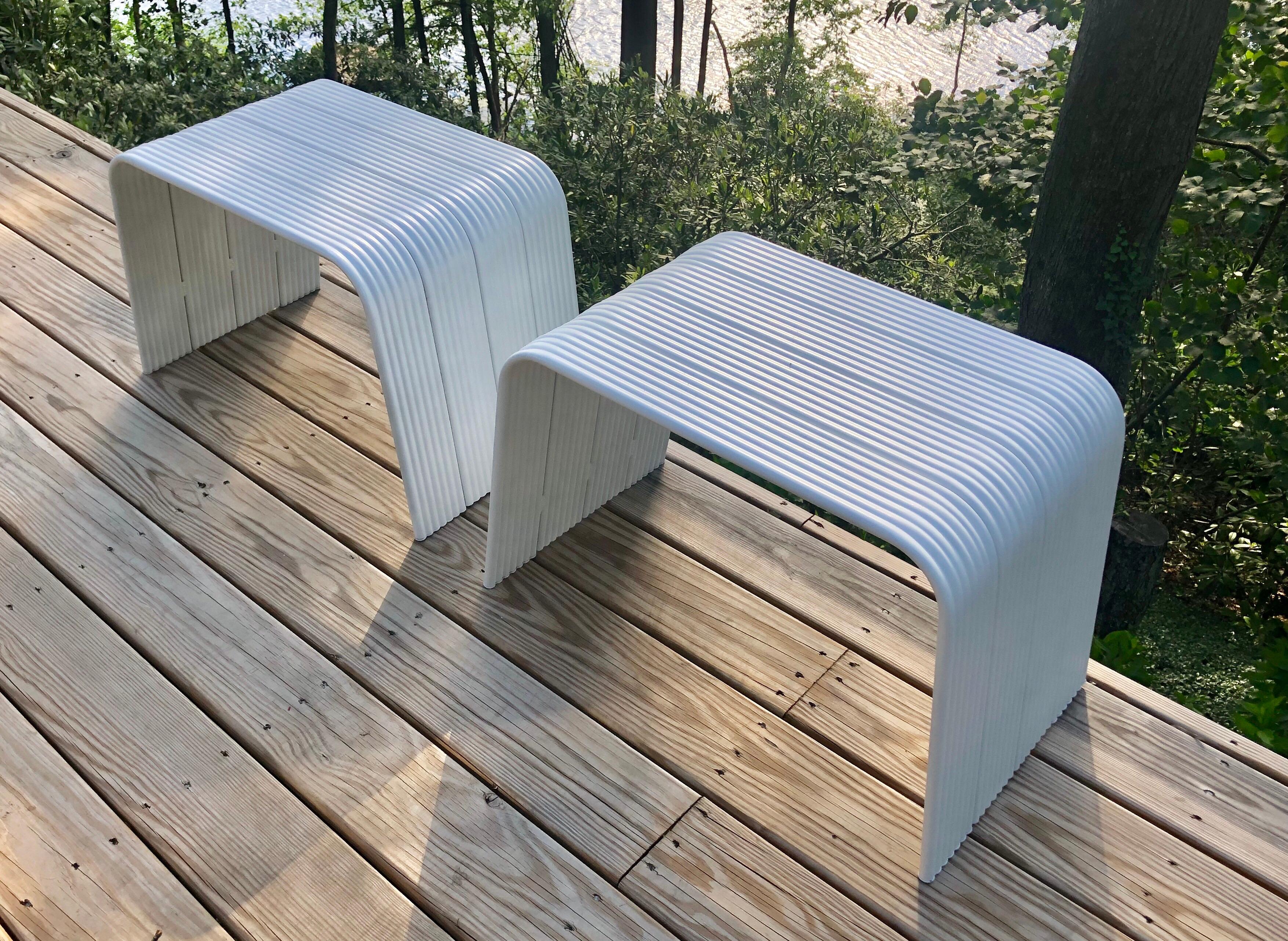 Pair of Italian Mid-Century Modern white enameled aluminum benches, stools or ottomans attributed to Superstudio.

The benches are in reverse U-shaped form and composed of a series of grooved pieces of aluminum. They are light and designed to be
