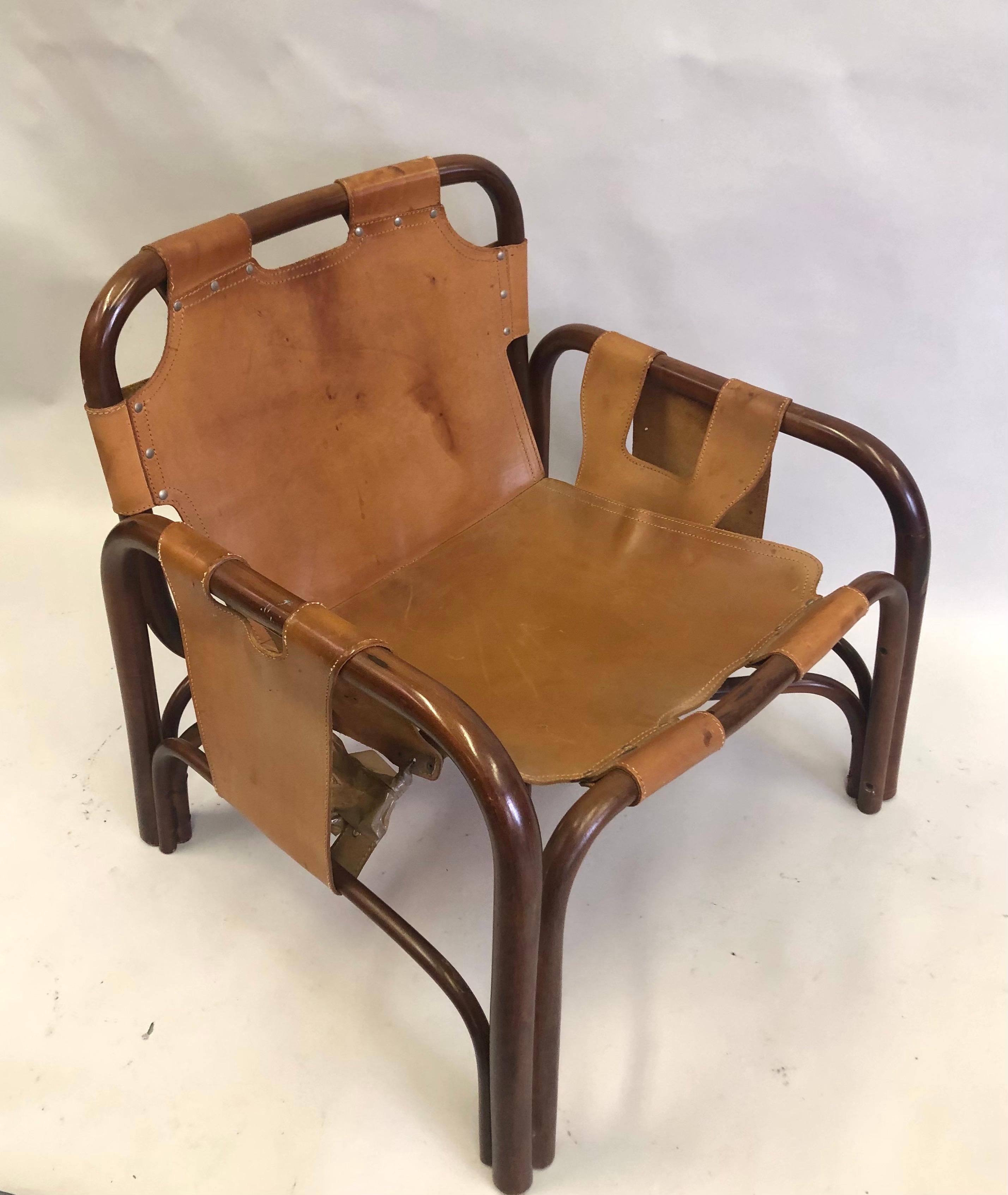 Elégante paire de chaises longues en bambou, rotin et cuir de vachette cousu à la main dans le style du maître français Jacques Adnet et Hermès. Les chaises sont construites sur un cadre en bambou et en rotin et luxueusement recouvertes de cuir