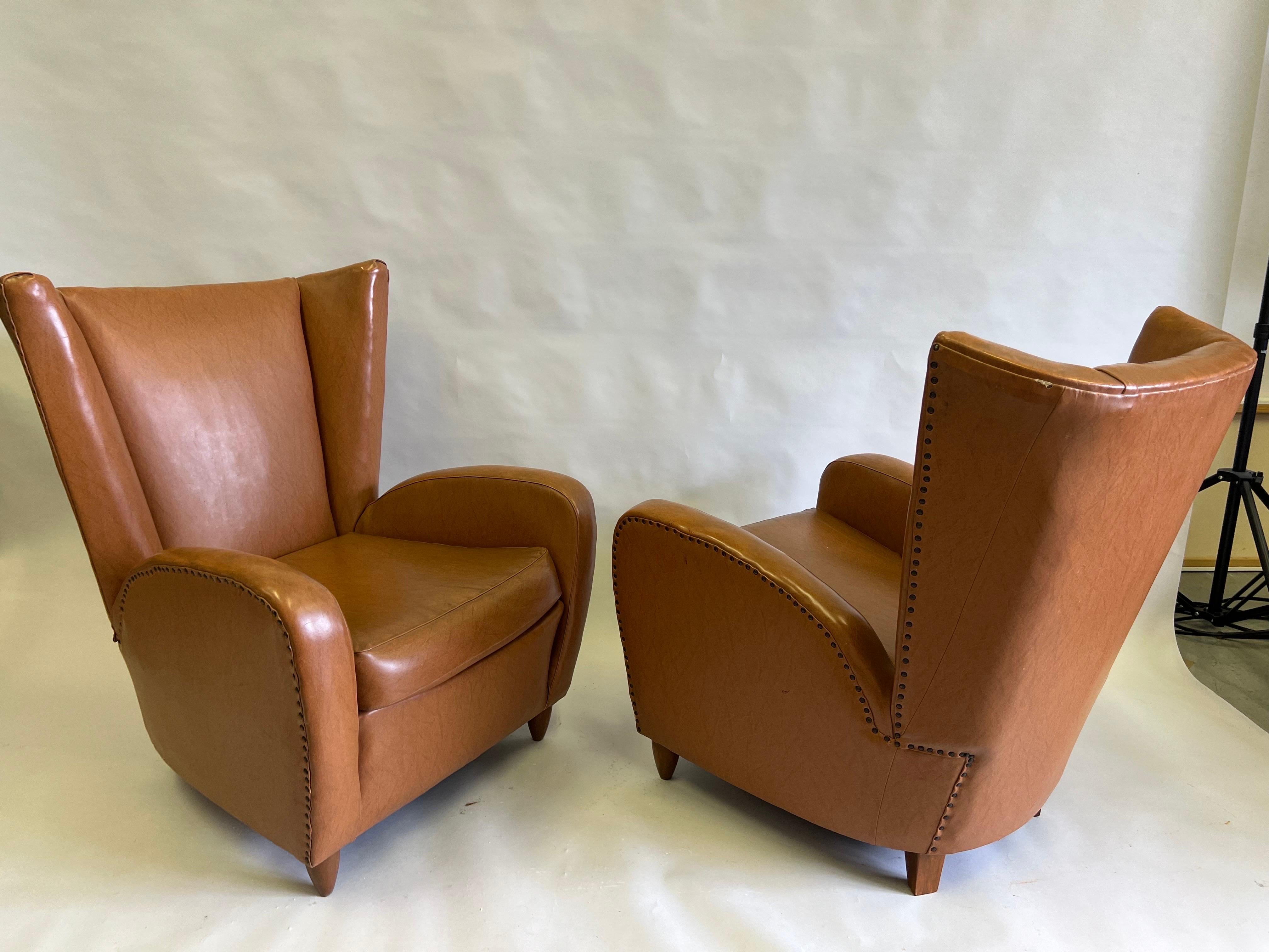 An Elegant and Timeless Pair of Italian Mid-Century Modern Neoclassical Wingback Lounge or Club  Chairs in Faux Leather by Paolo Buffa, Italy, circa 1947. These armchairs chairs are special objects of design with their dynamic form and smooth,