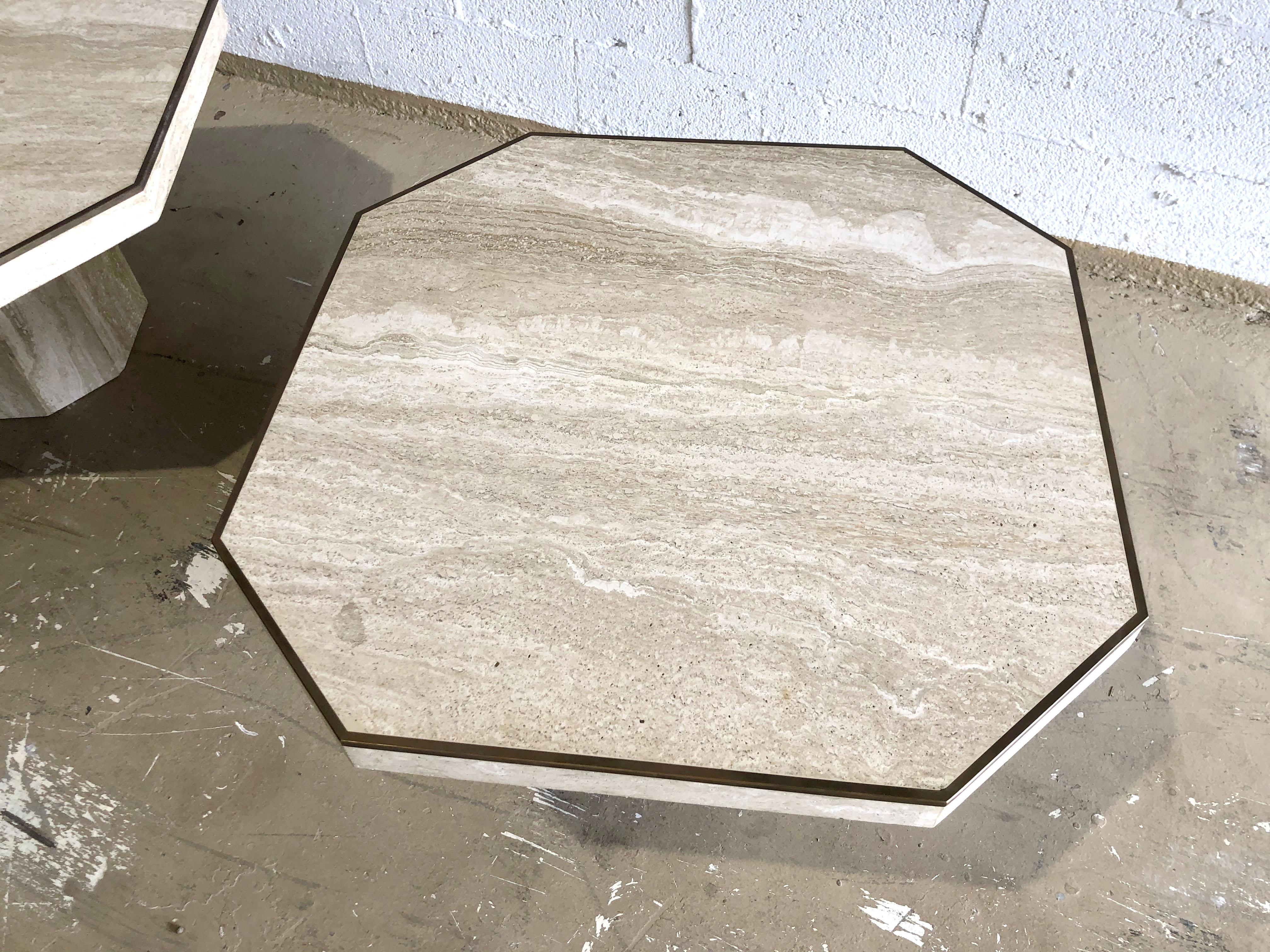 Coppia di tavolini in marmo di travertino con piano quadrato e angoli inclinati su una base conforme.