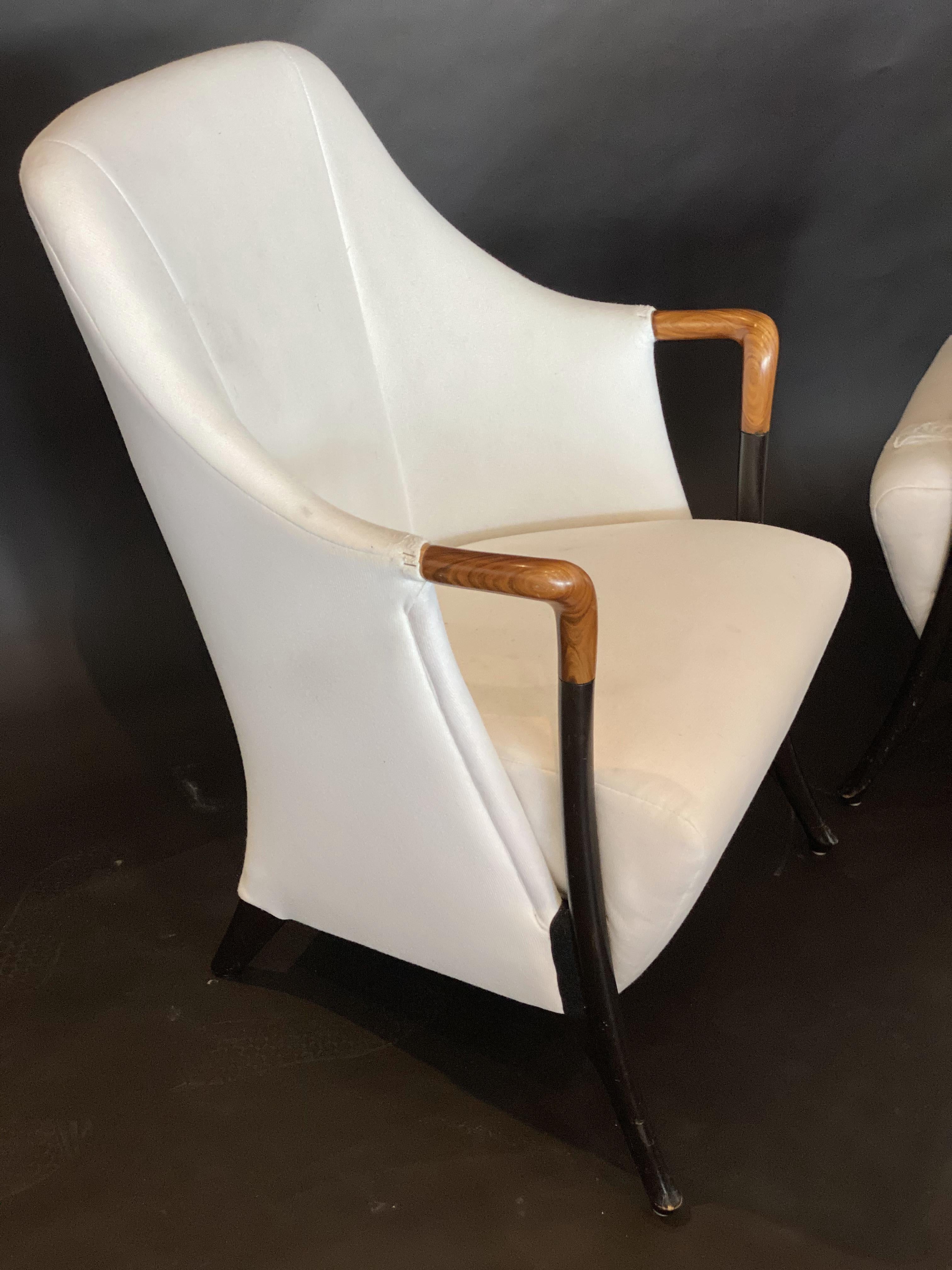 The arched upholstered back and seat with 2 sweeping arms in polished walnut and terminating in ebonized splayed legs. Umberto Asagno started working for Giorgetti in 1968, and became head designer and led their reseach center for design. He is