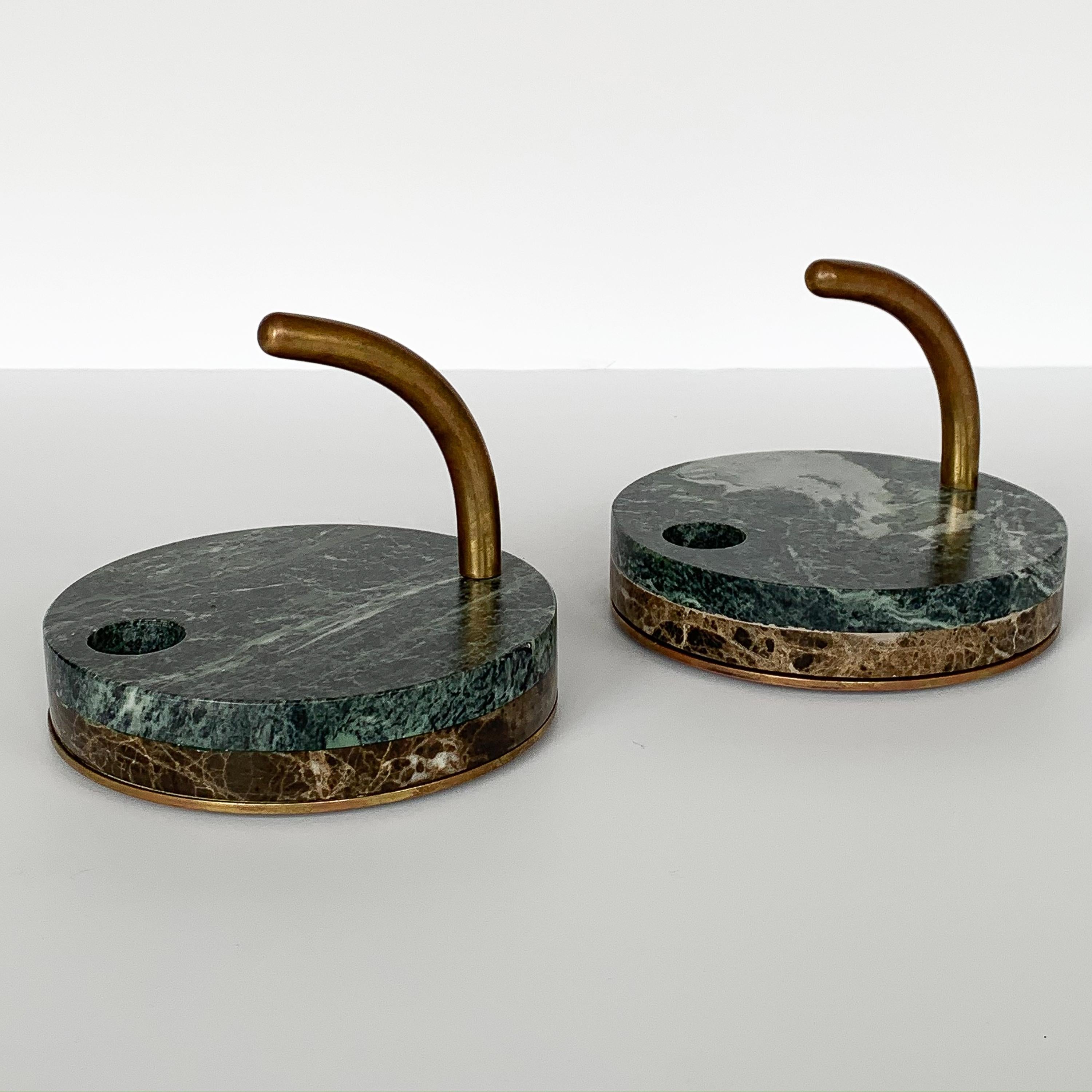 Pair of Italian modernist marble and bronze candleholders, circa 1980s. Bronze bases with layered brown and green marble. Bronze arched handle. Hole fits two different sized candles, a standard 3/4