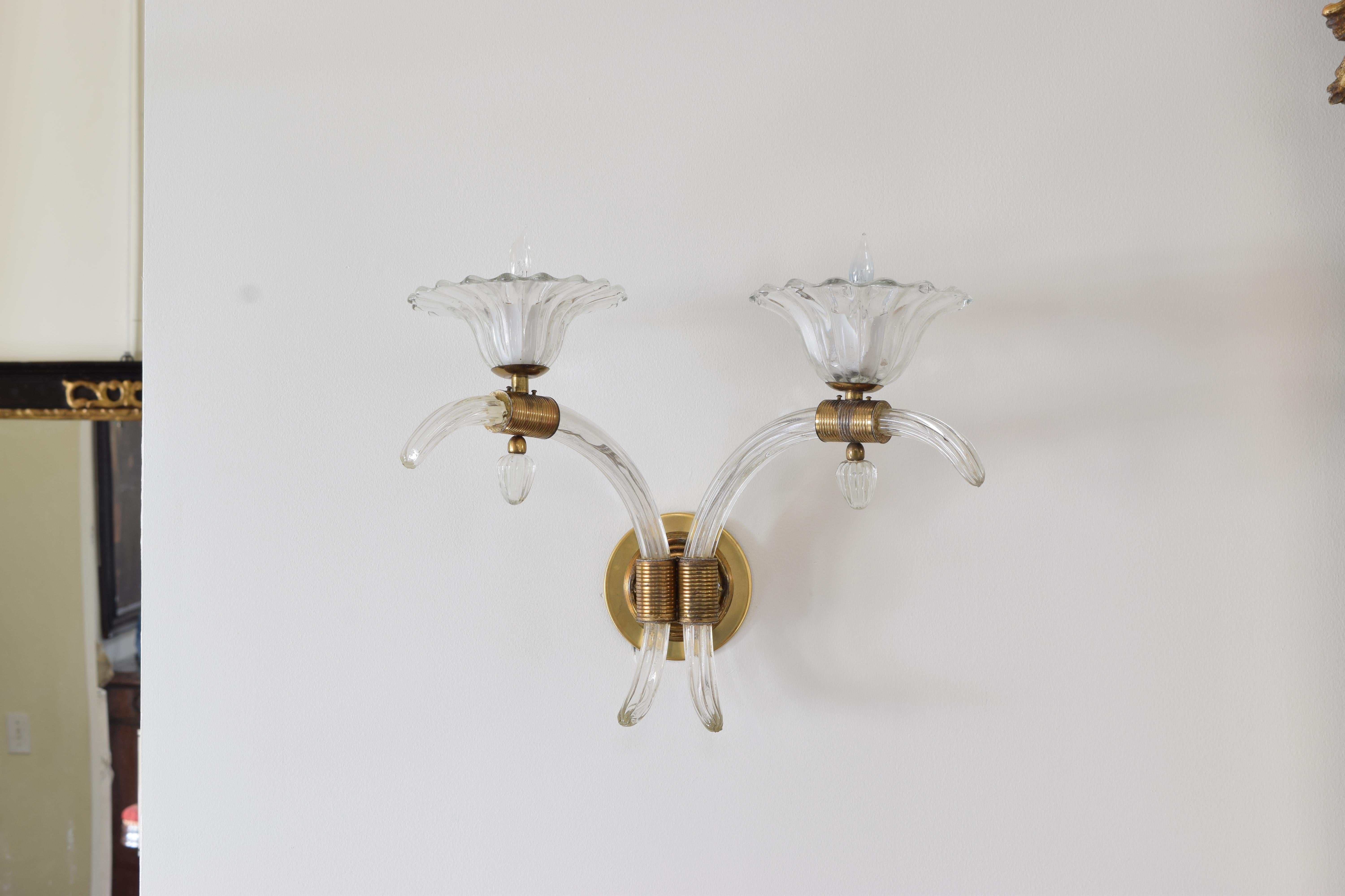 The circular bass backplates with molded keepers issuing blown glass arms both upper and lower, the blown glass shades atop molded brass mounts.