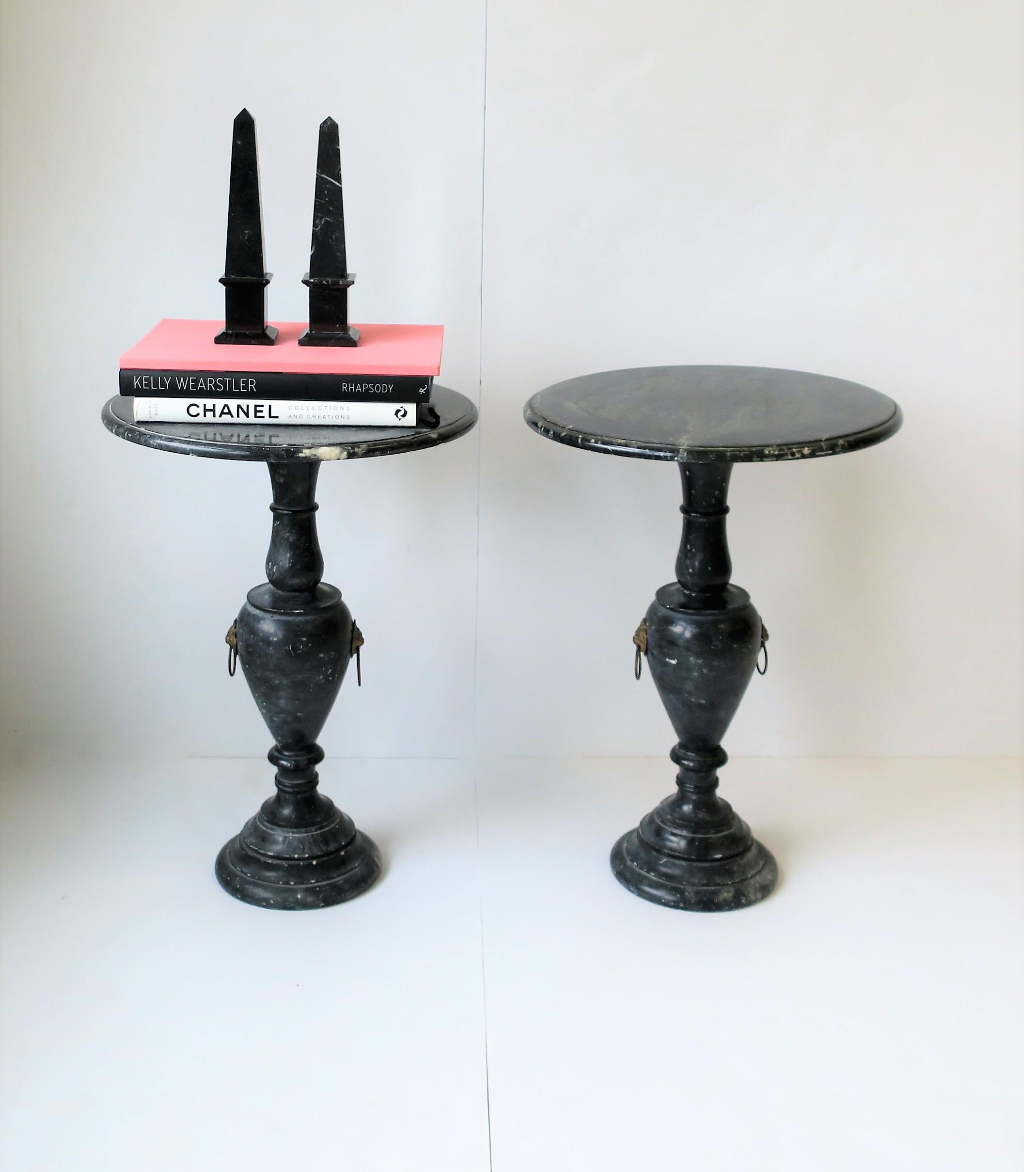 A beautiful and substantial pair of Italian Regency style black and white marble round gueridon side or end tables with decorative brass lion-head detail, circa Mid-20th Century, Italy. Tables are solid, beautifully carved and polished smooth with