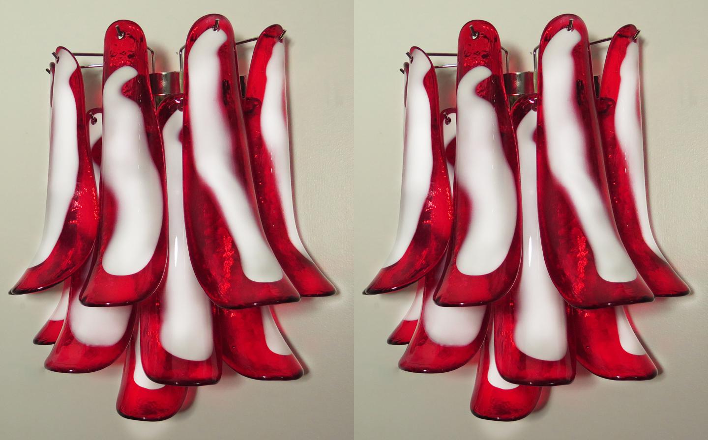 Pair of vintage Italian Murano appliques in the manner of Mazzega. Wall lights have 10 red and white “lattimo” glasses (for each applique) in a nickel-plated metal frame.
Period: 1980s
Dimensions: 16.50 inches (42 cm) height; 13.80 inches (35 cm)