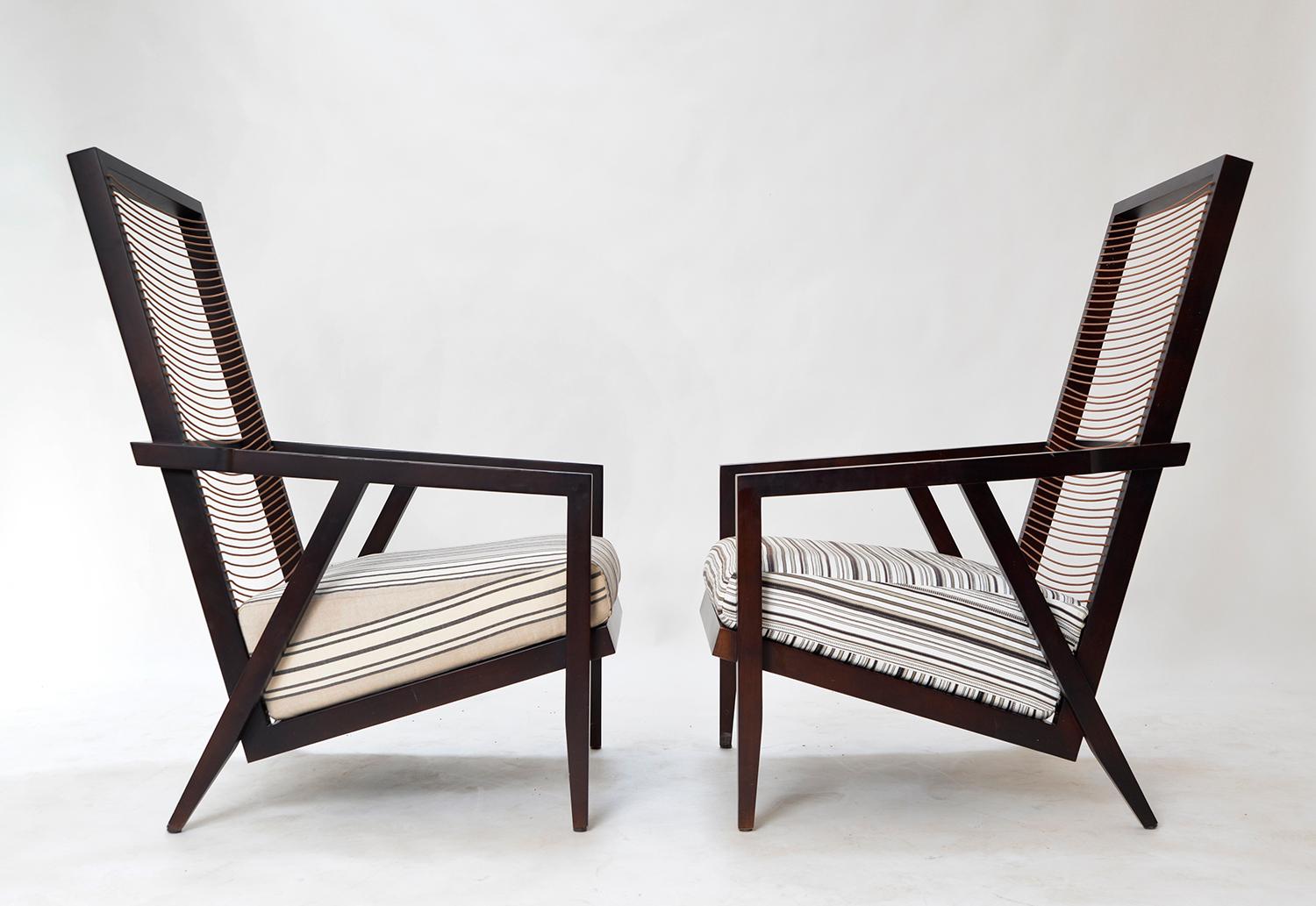 Two Astoria high back lounge chairs designed by Franco Bizzozzero and manufactured by Pierantonio Bonacina, one retaining the maker’s label.
The angular design is made from stained wood, the colour a dark reddish brown – almost black. The strung