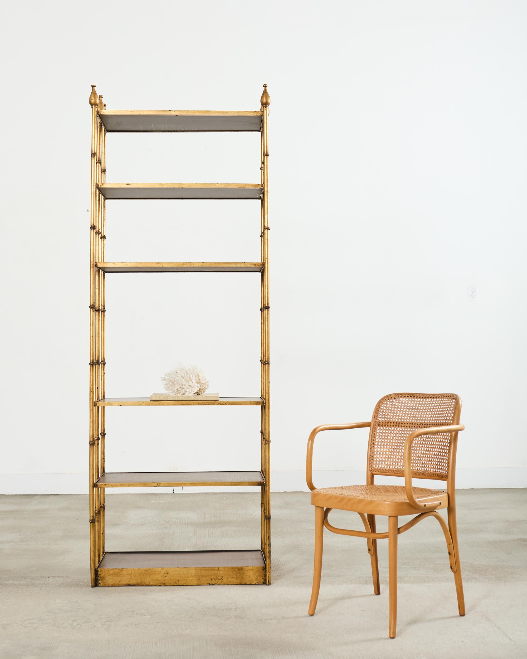 Fantastic pair of matching mid-century modern Italian Regency etagere display shelves or bookcases. The shelves feature a dramatic gilt finish on the iron faux bamboo frames. The six shelves have veneered wood bottoms measuring 3, 17, 31, 54, 67 and