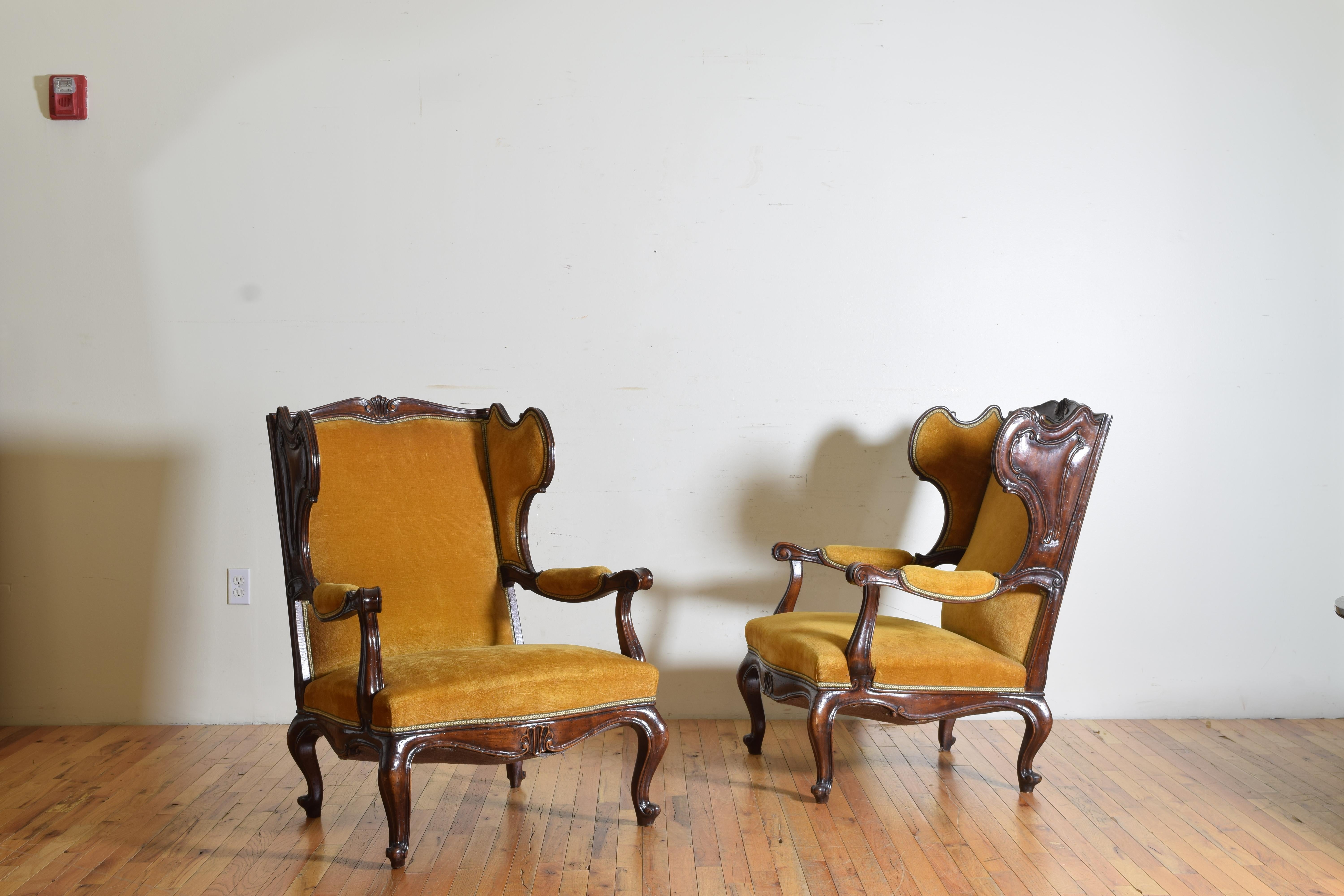 In the Venetian style, elaborately carved and shaped wings flanking a slightly arched and shell carved backrest, the arms with elbow pads and descending into generously proportioned seats, the apron with a centered shell carving and raised on